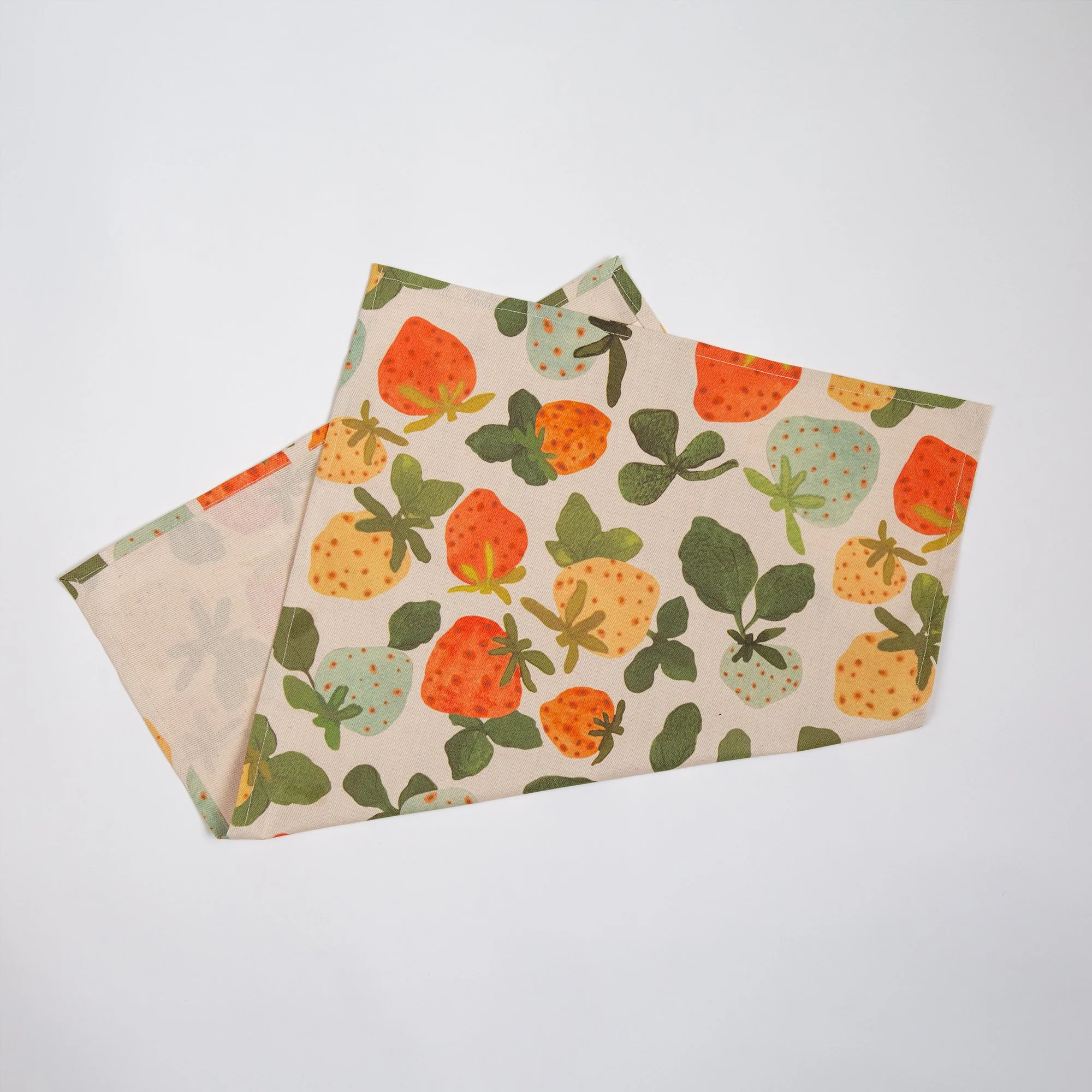 Colourful strawberry tea towel featuring a playful print of yellow, red, pink and blue hand-drawn strawberries.