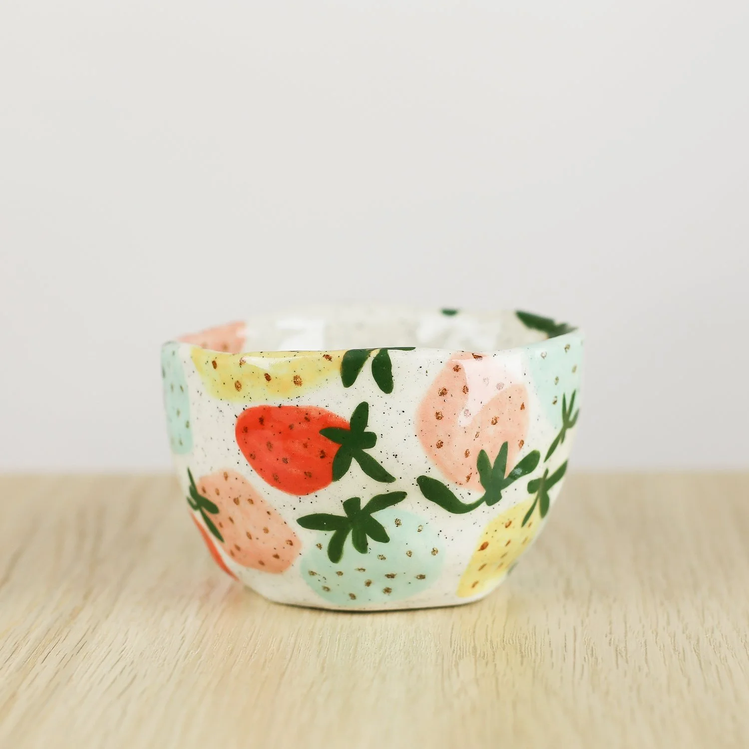 Handmade ceramic cup with hand-painted strawberries in red, pink, yellow and blue. Holds 150ml. A unique, playful coffee cup for everyday use.