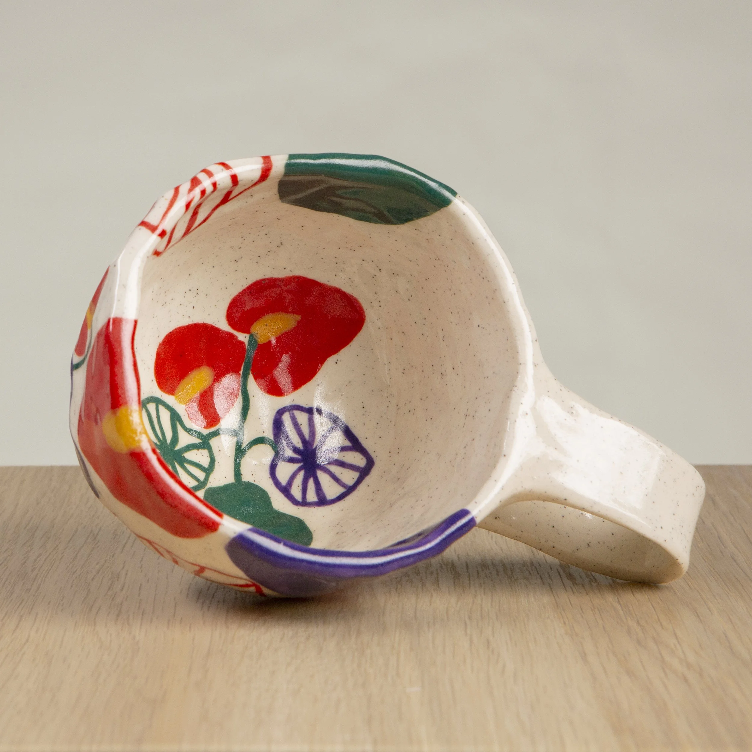 Handmade ceramic mug with hand-painted anthurium flower design, crafted from speckled clay in Melbourne. Holds approximately 300ml.