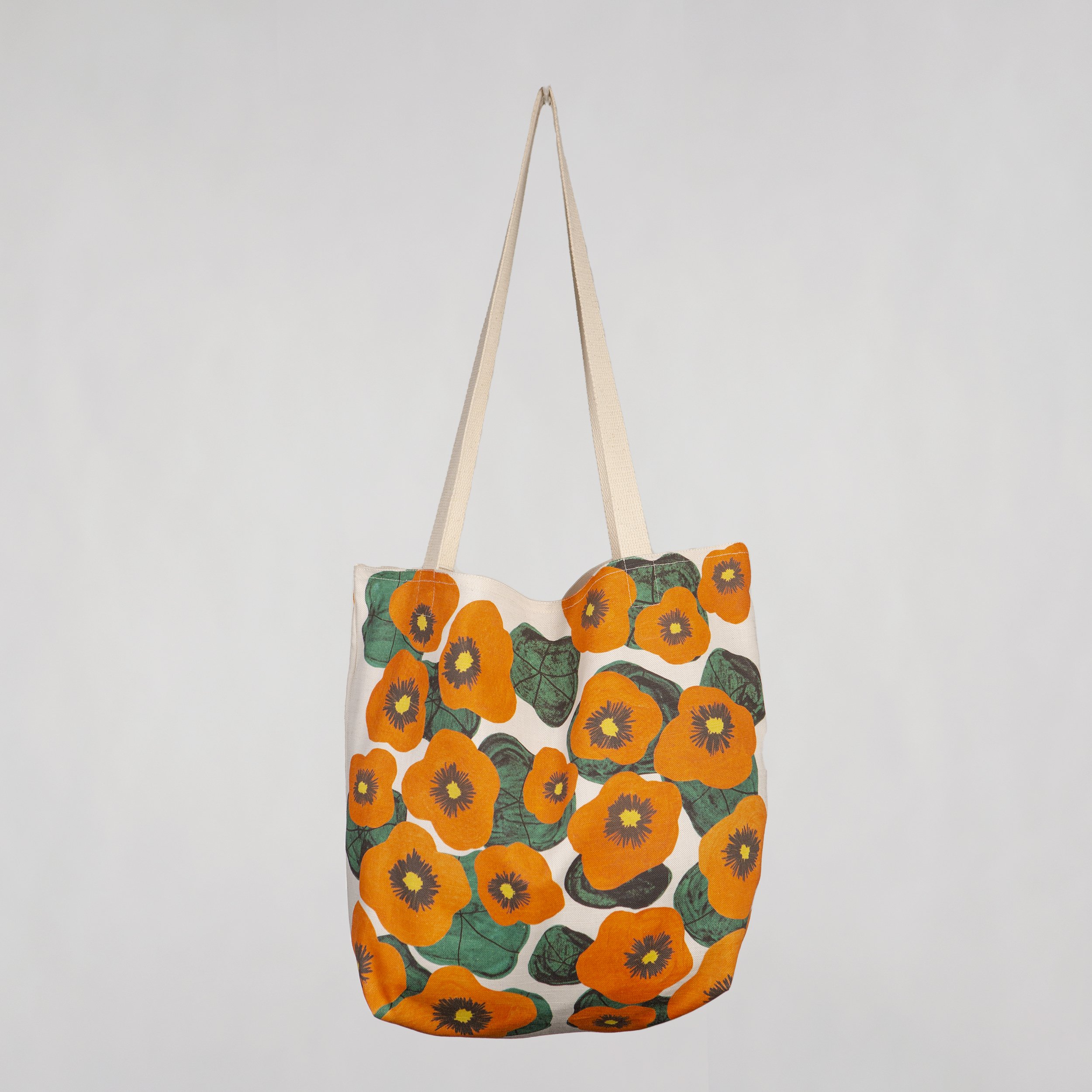 Cotton linen tote bag with a hand-drawn nasturtium print, hanging on a wall. Soft, structured, and made in Melbourne.