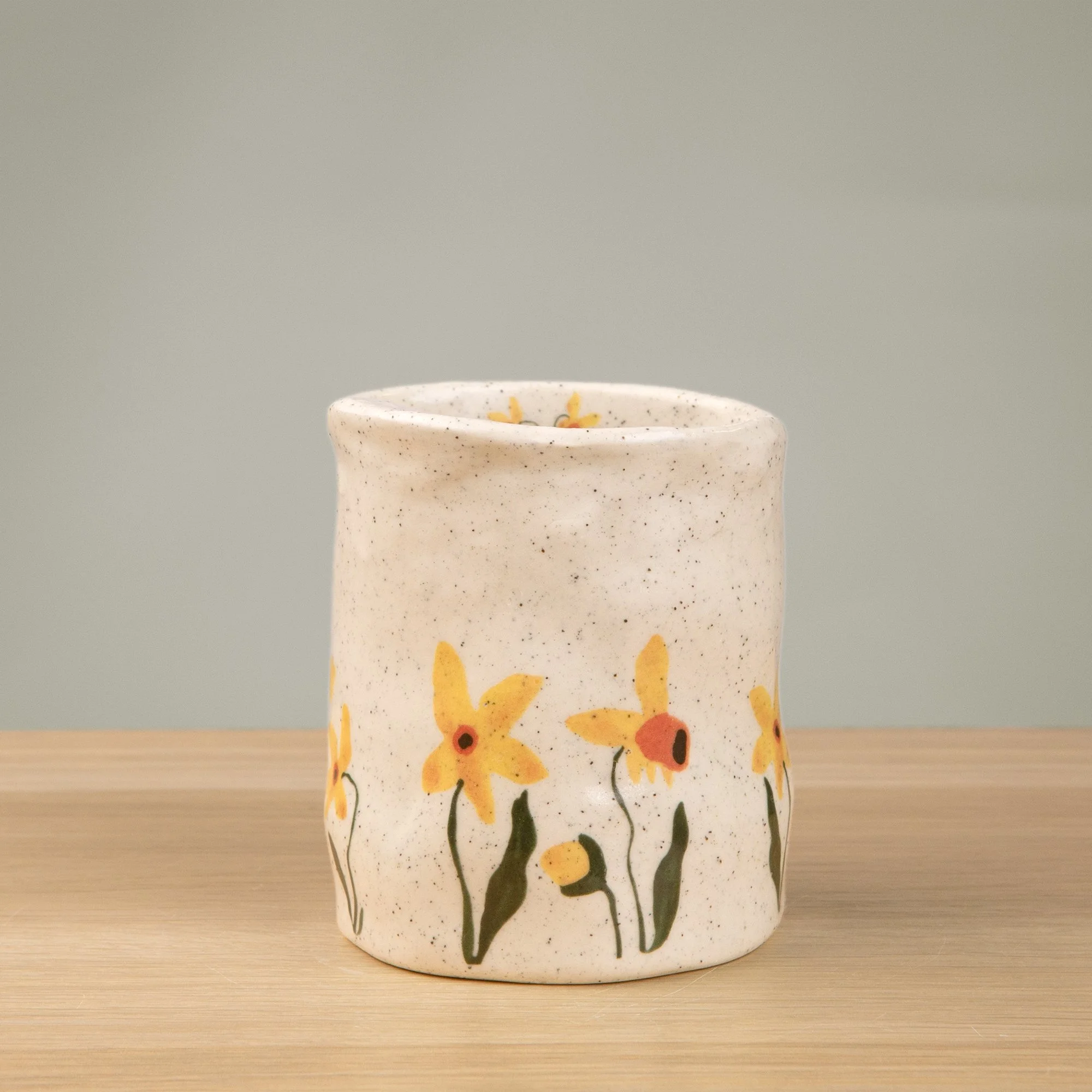 Handmade speckled ceramic daffodil travel cup decorated with sweet daffodil flowers illustrations