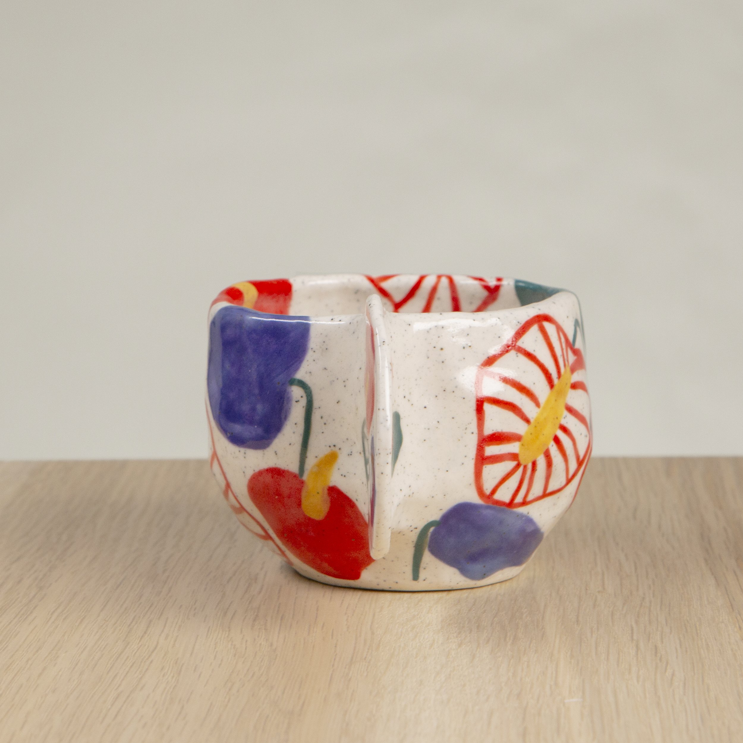Handmade ceramic coffee cup with hand-painted anthurium flowers, crafted from speckled clay in Melbourne with a cute petal handle. Holds approximately 150ml.
