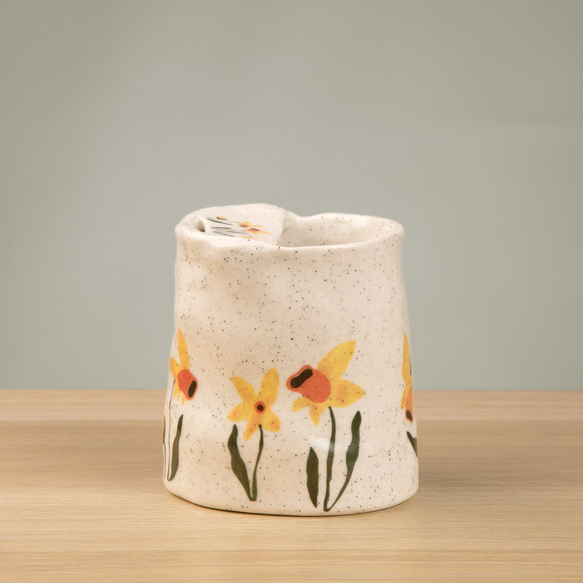 Handmade speckled ceramic daffodil travel cup decorated with sweet daffodil flowers illustrations
