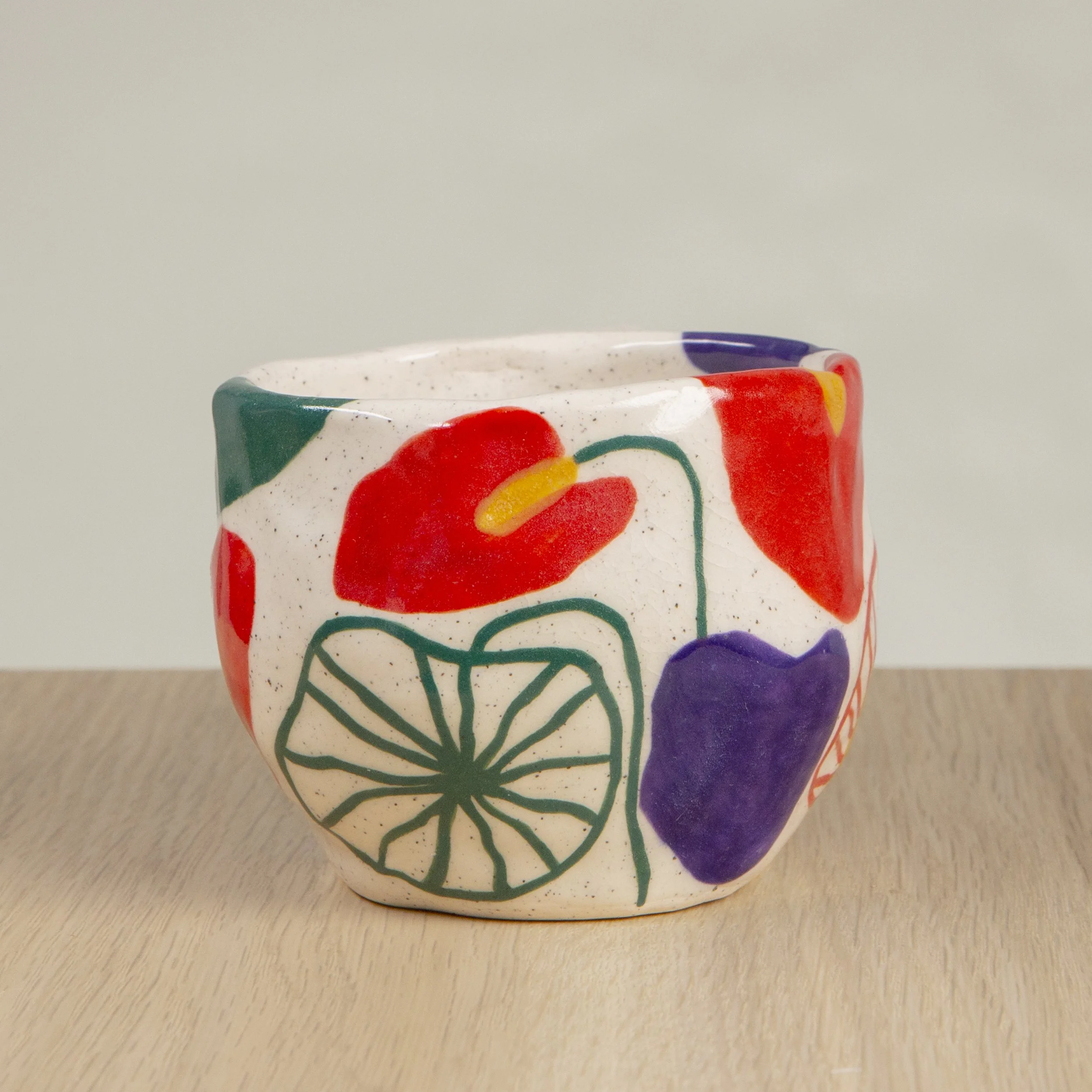 Handmade ceramic coffee cup with hand-painted anthurium flowers, crafted from speckled clay in Melbourne. Holds approximately 150ml.