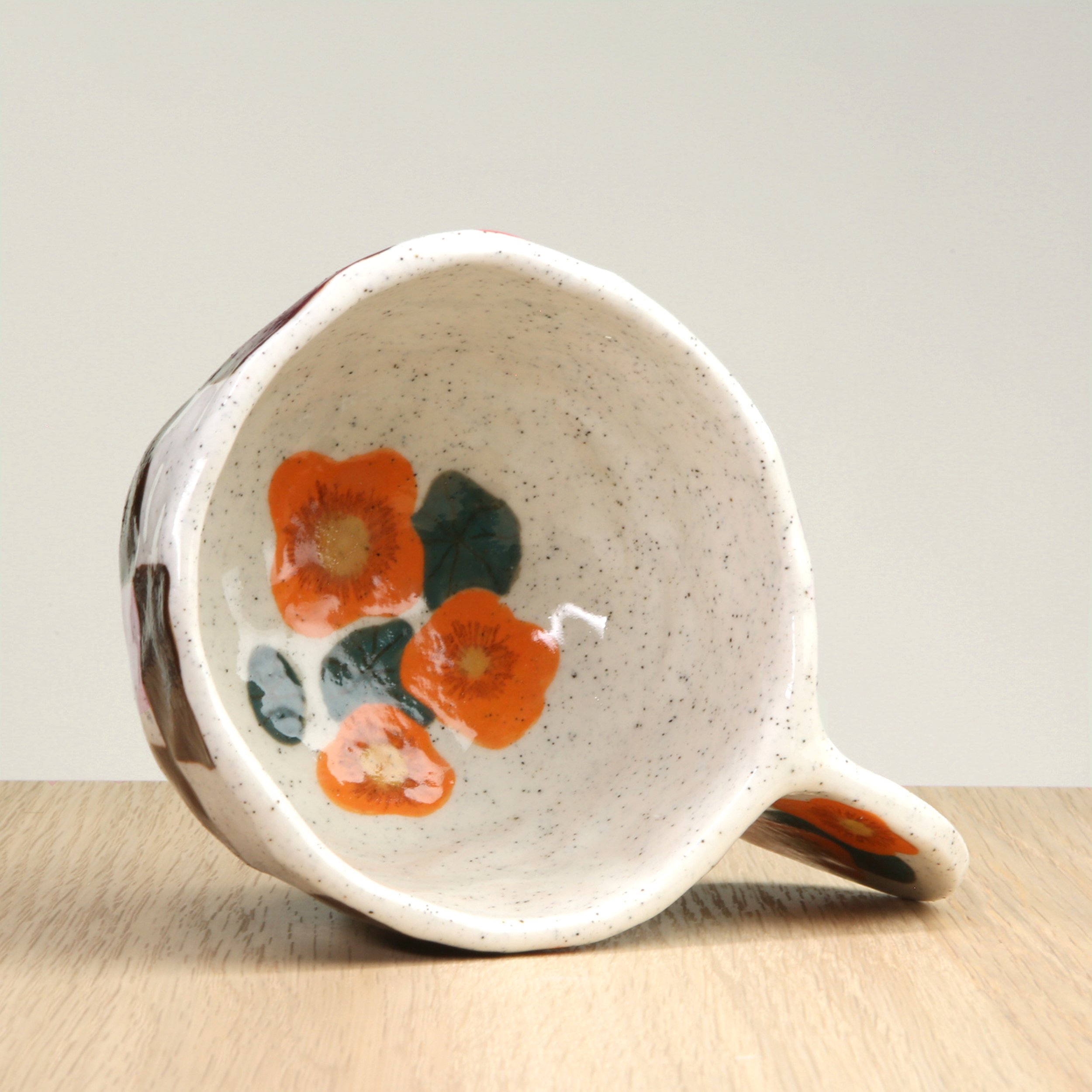 Handmade ceramic coffee cup with hand-painted nasturtium flowers & a chocolate check, crafted from speckled clay in Melbourne. Holds approximately 150ml.