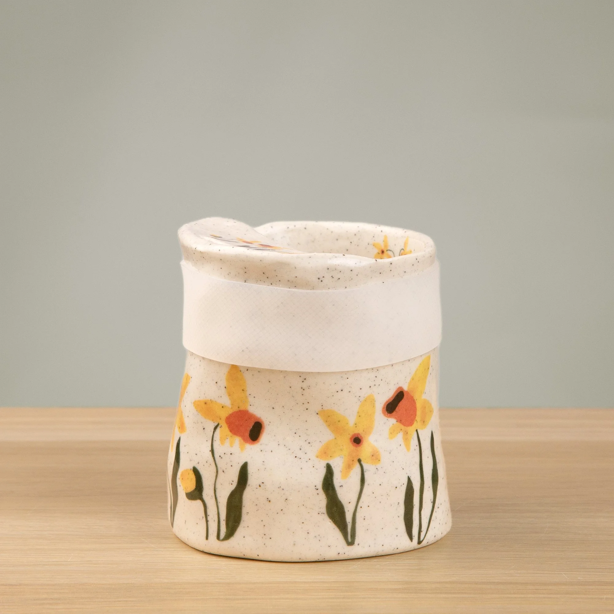 Handmade speckled ceramic daffodil travel cup decorated with sweet daffodil flowers illustrations