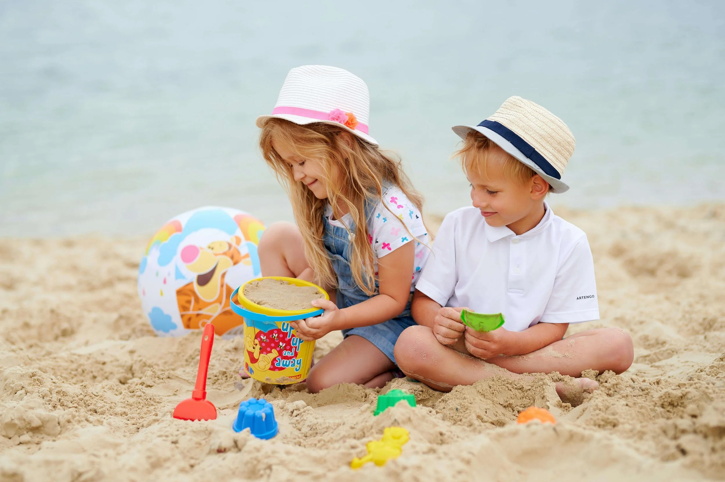 Two young children play in the beach sand. Does your child's summer behavior leave you wondering what's really going on? Family therapy in Arcadia, CA can help your family build understanding and stronger communication all season long.