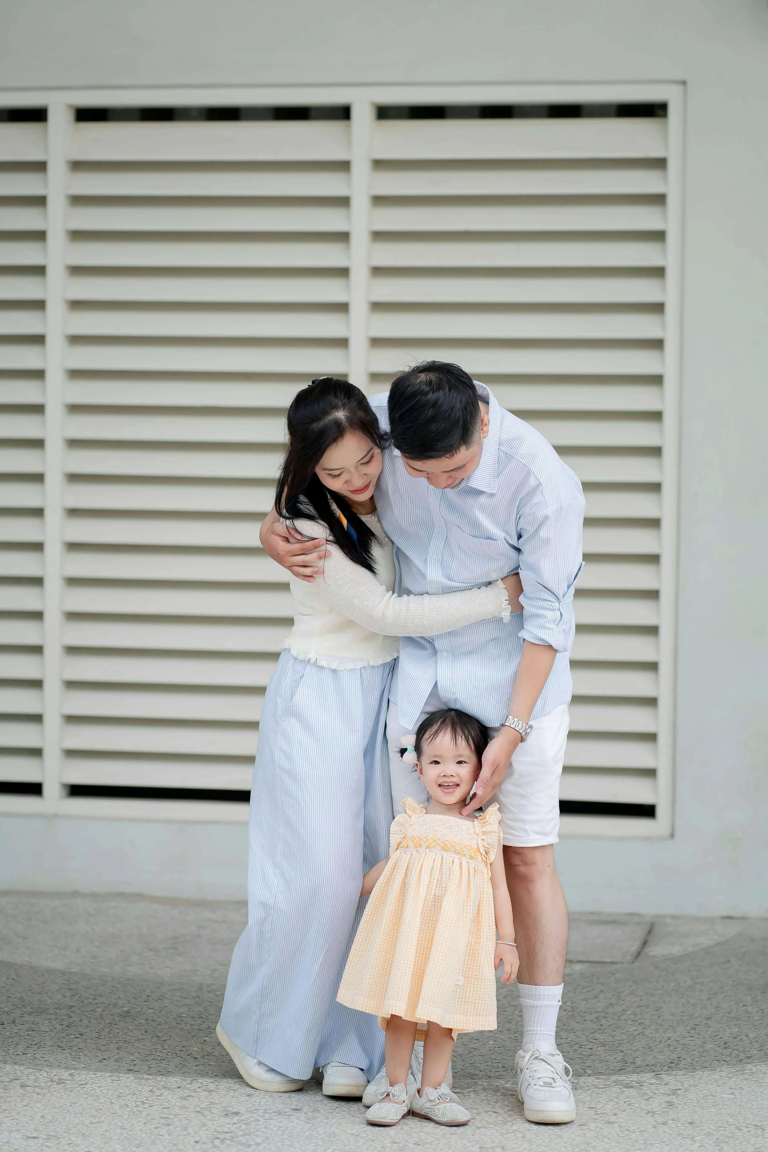 A young Asian family stands closely together outdoors. Looking for support that understands the cultural values and dynamics shaping your relationships? An AAPI family therapist in Arcadia, CA, can help foster deeper connection & understanding.
