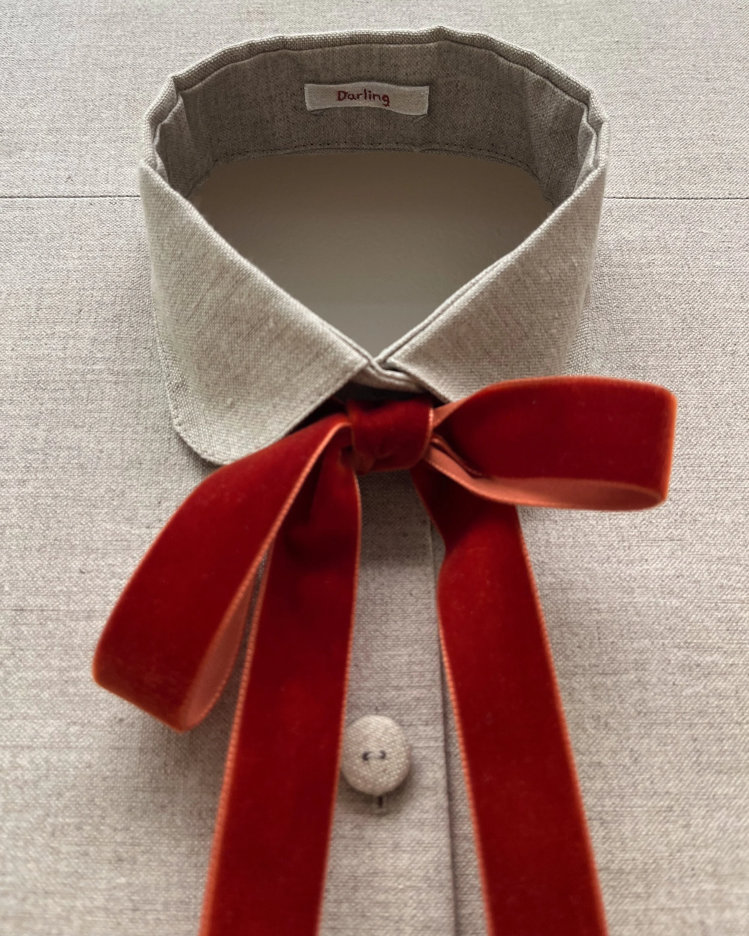 The Truth-teller, 2025 | Oil, cotton thread, linen covered buttons and velvet ribbon on linen