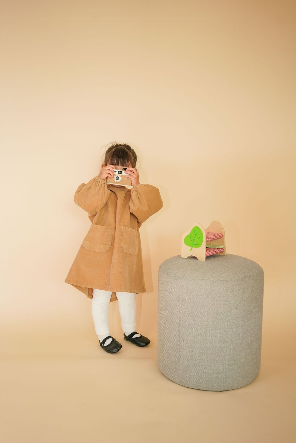 Girl's corduroy dress, highlighting A-line silhouette, mid-high collar, and oversized fit