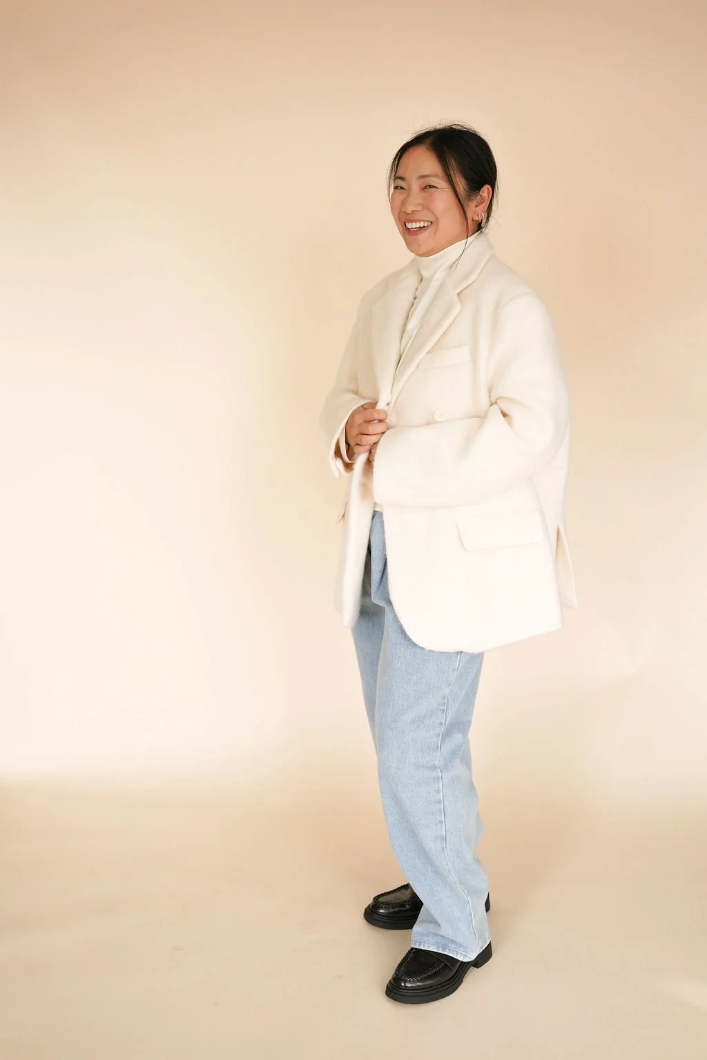 Cozy wool-blend coat in Ivory, featuring double front button closure, flap pockets with color-matched buttons, and a versatile one-size fit