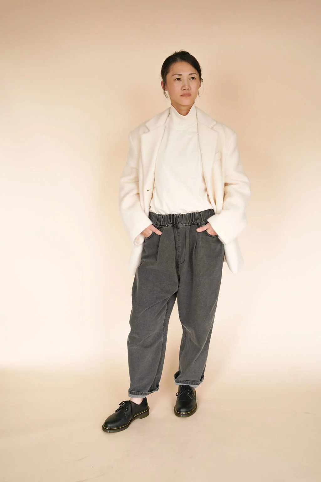 Model wearing Silver wool-blend coat styled casually, showcasing a loose fit with flap pockets and versatile double-button design