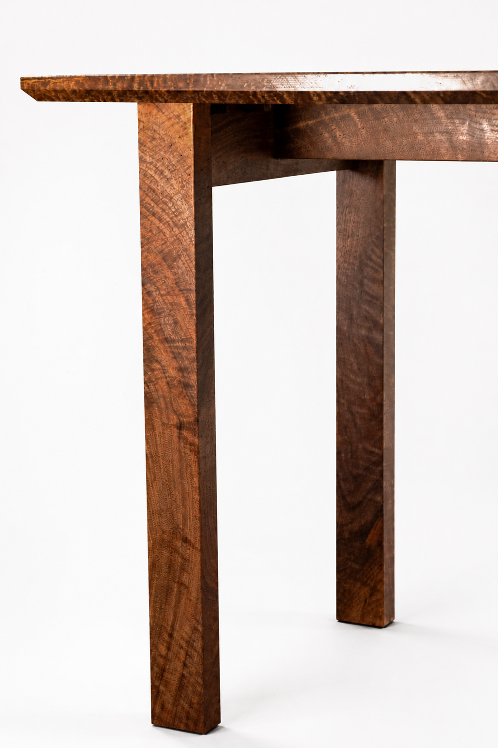 Close-up of a highly figured curly wooden walnut table leg with a rich, textured finish against a plain white background.