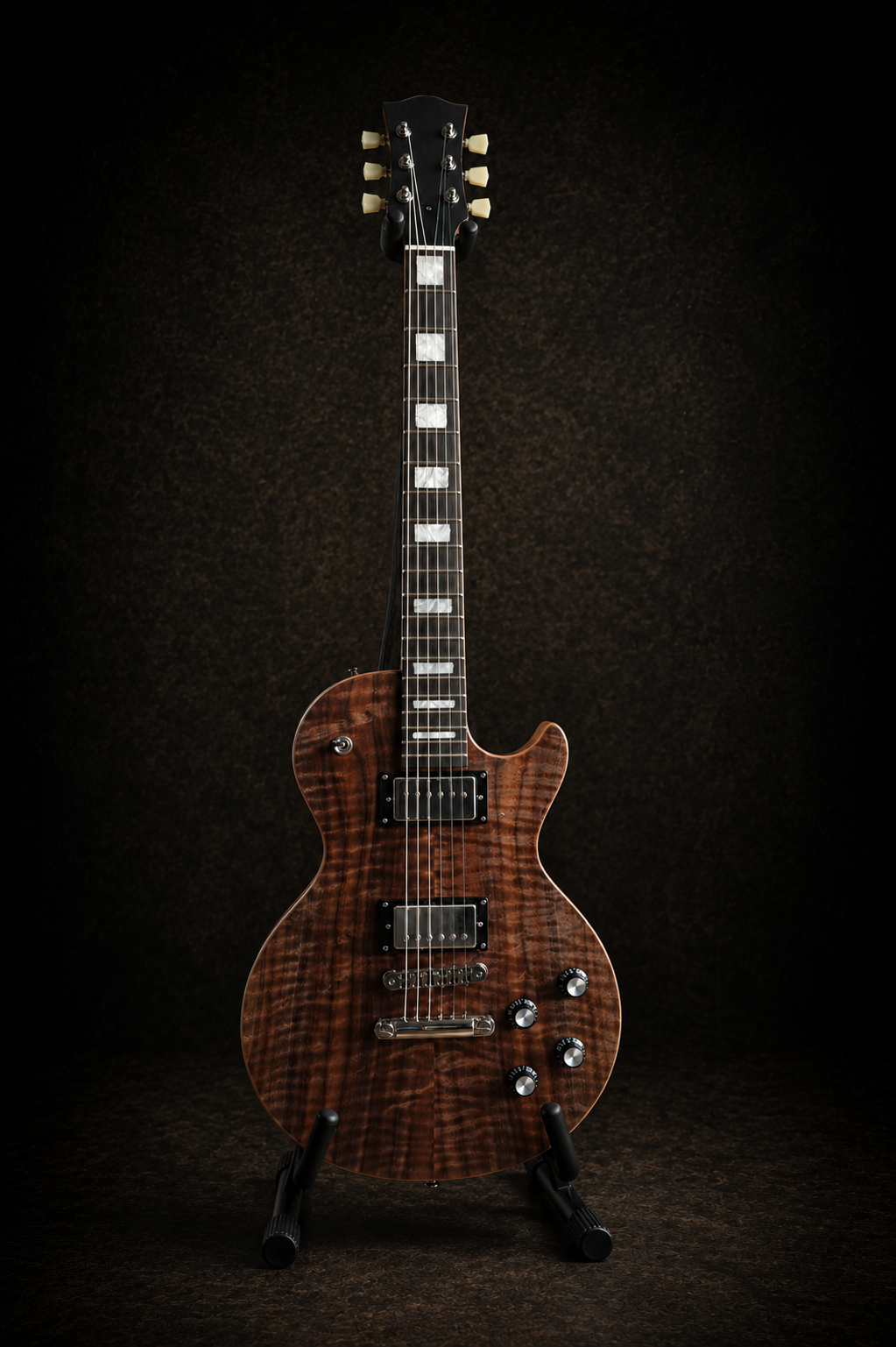 A brown electric guitar with a quilted maple top, black hardware, and chrome tuning pegs, standing on a black guitar stand against a dark background.