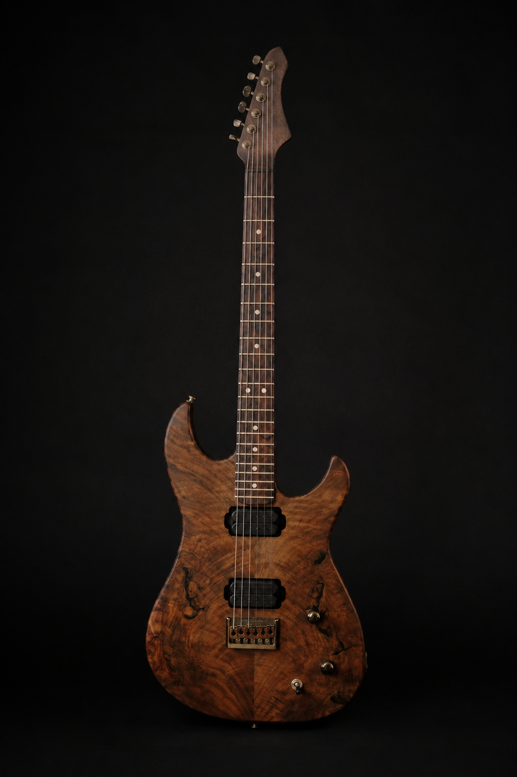 An electric guitar with walnut top, black pickups, and an intricate body design, standing on a guitar stand against a dark background.