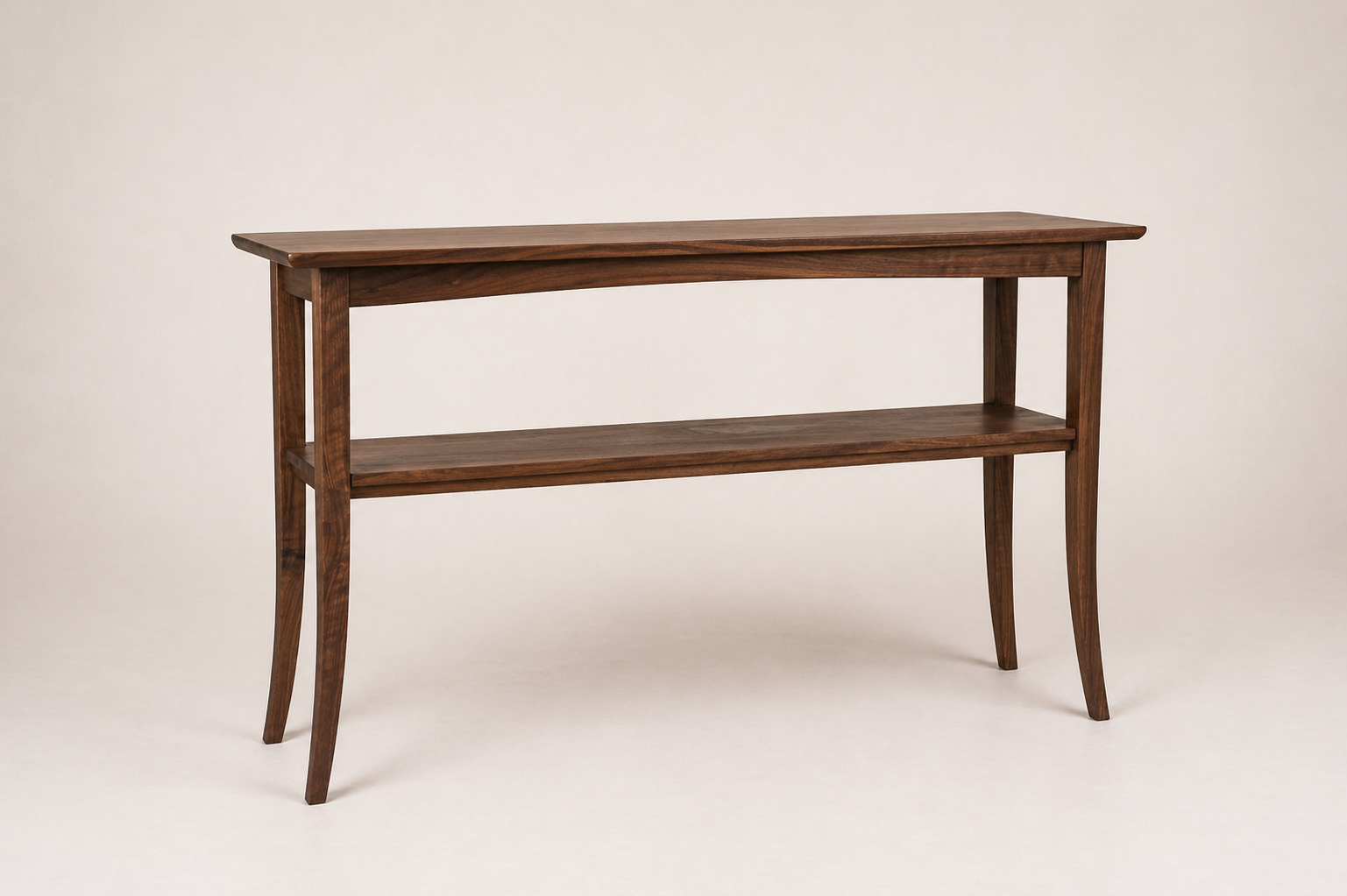 A custom black walnut console table with a lower shelf, standing on four slightly curved legs. Made by Von Boyle Woodworking Co.