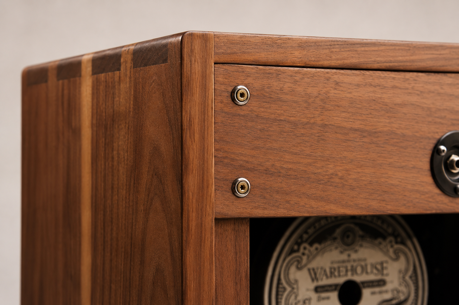 Close-up of a wooden cabinet with metallic fixtures and a partially visible vintage-style label inside.
