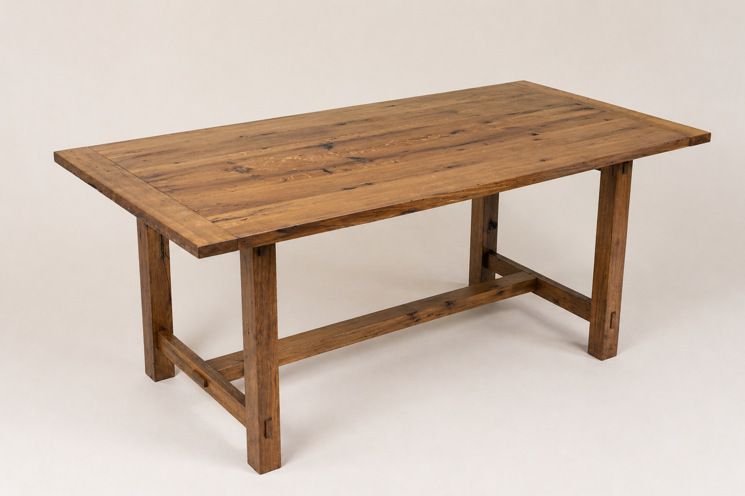 A wooden table with a natural finish, featuring a rectangular top and sturdy legs, set against a plain light background.