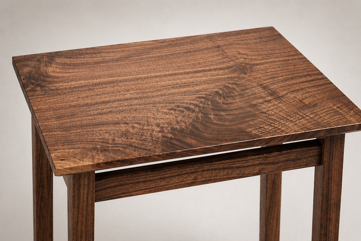 Close-up of a wooden table with a natural grain pattern on the surface, showing warm brown tones.