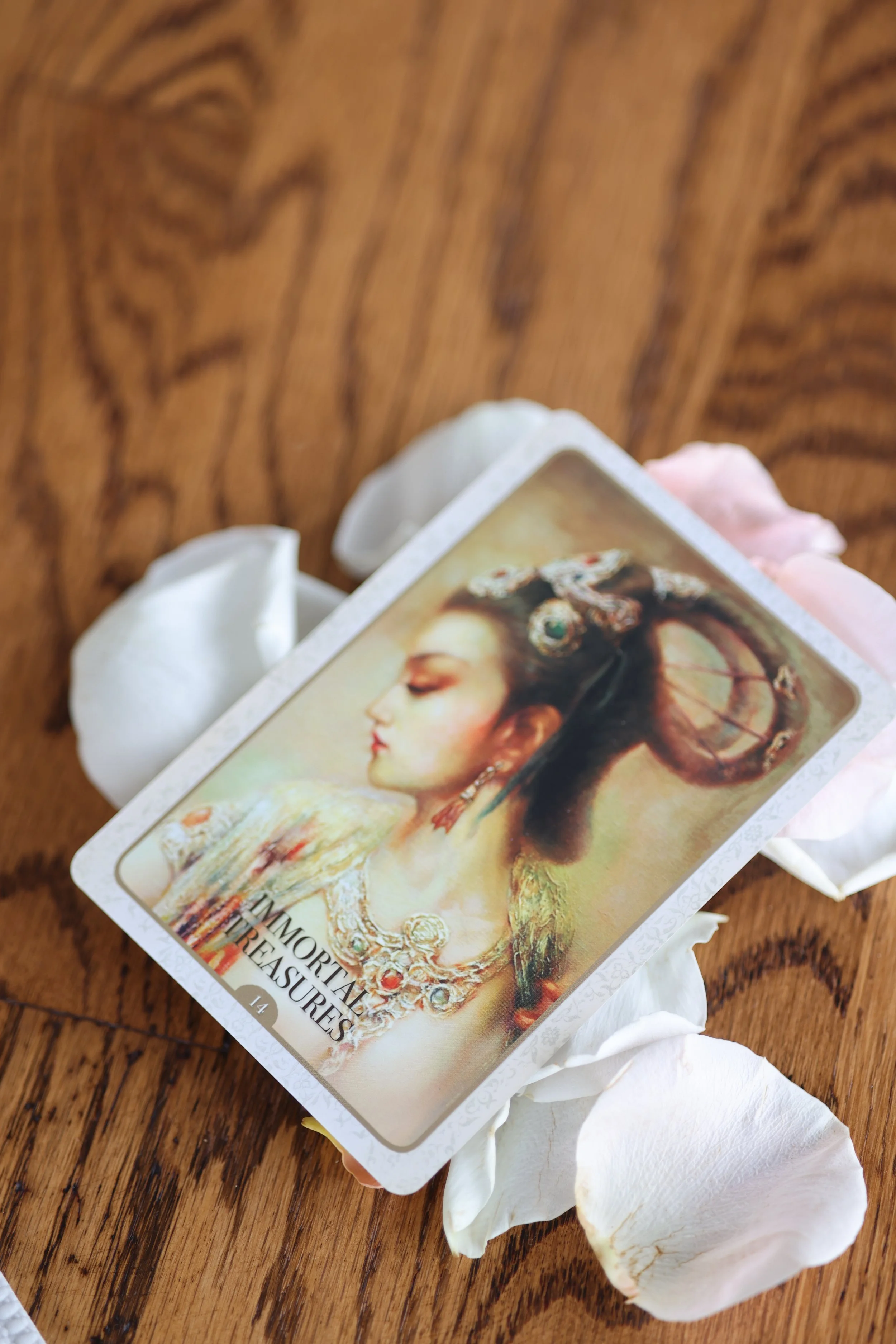 A card titled 'Important Treasures' with a profile of a woman in historical attire, laying on a wooden surface surrounded by white rose petals.