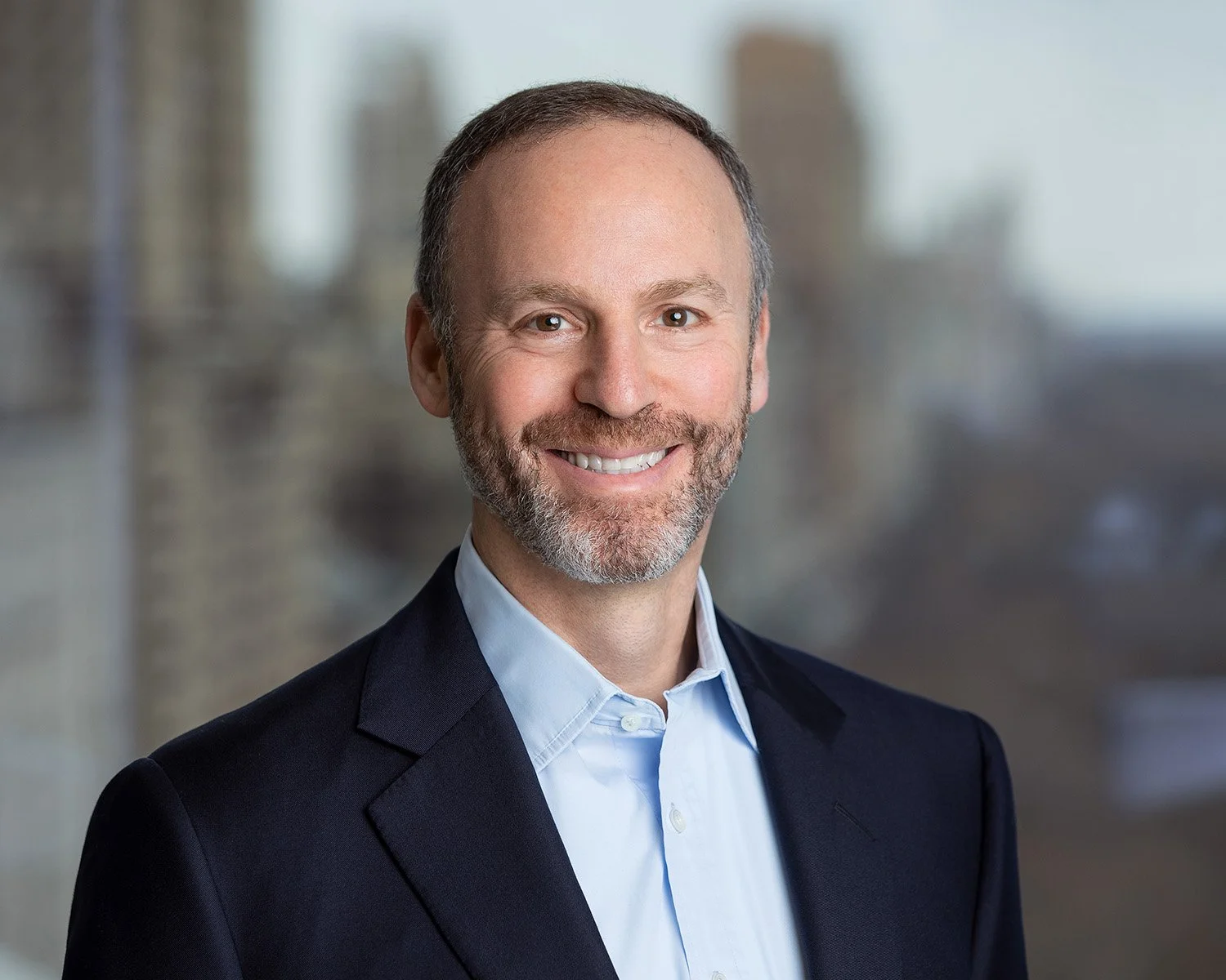 Headshot in front of NYC Office window