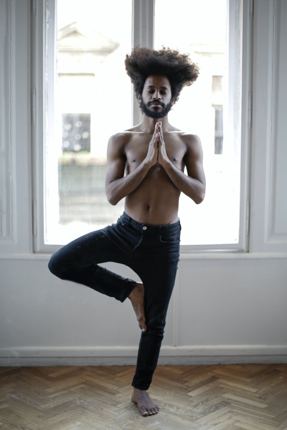 Man standing in yoga tree pose.