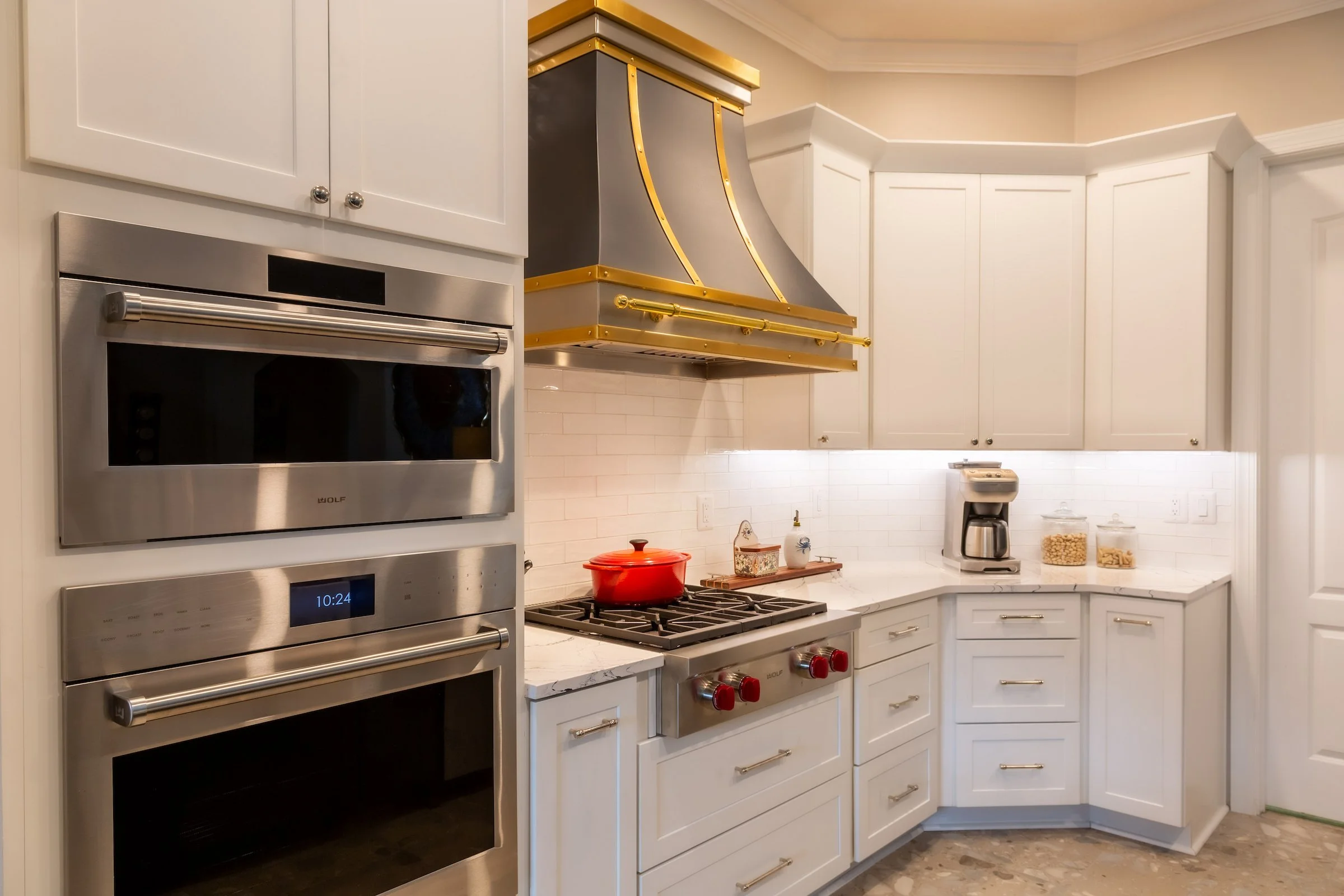Image of a kitchen with white cabinets and nee appliances.