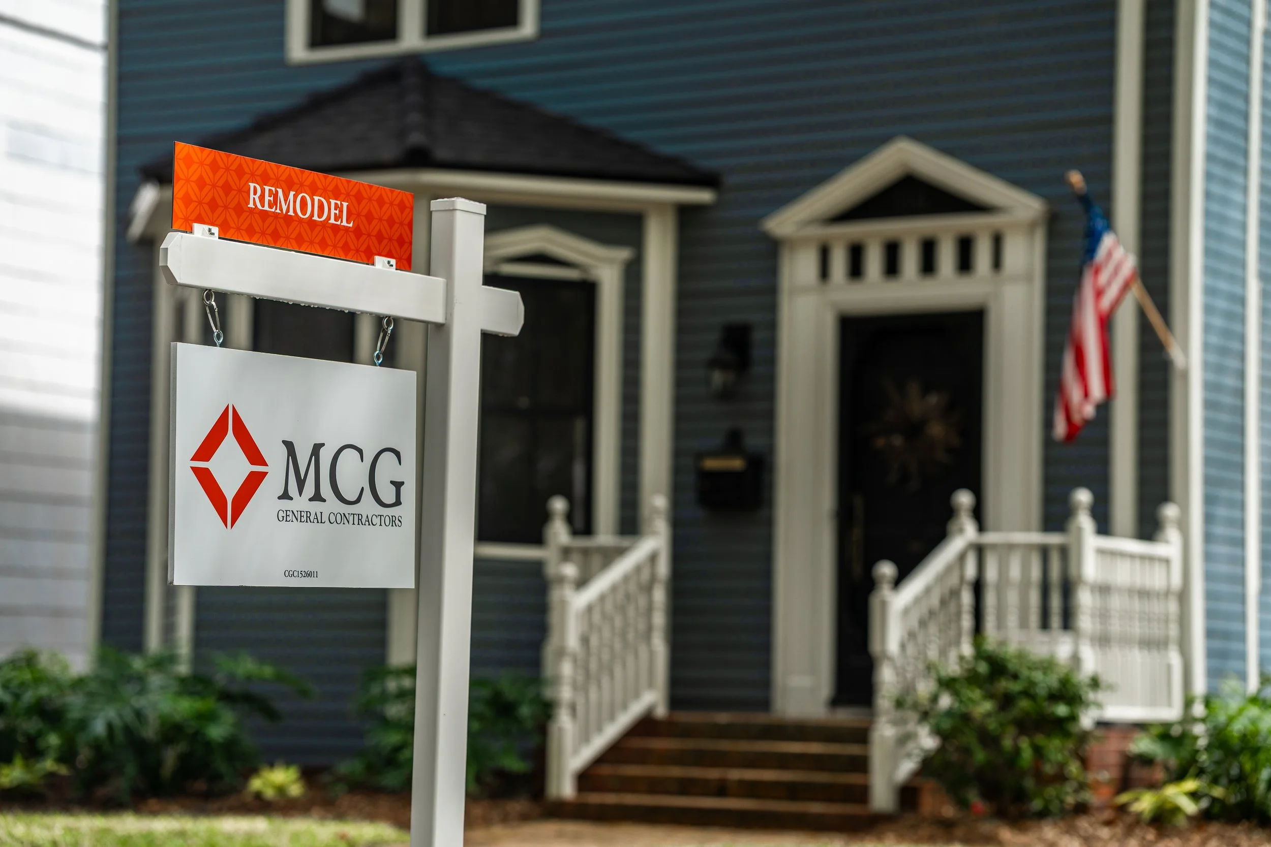 MCG General Contractors remodel yard sign displayed in front of blue residential home with white porch in Jacksonville.