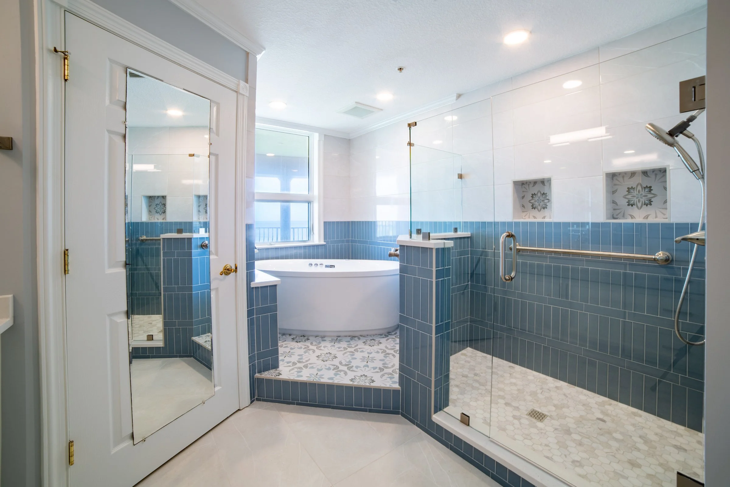 White and blue bathroom with a stand alone tub and a walk in shower.