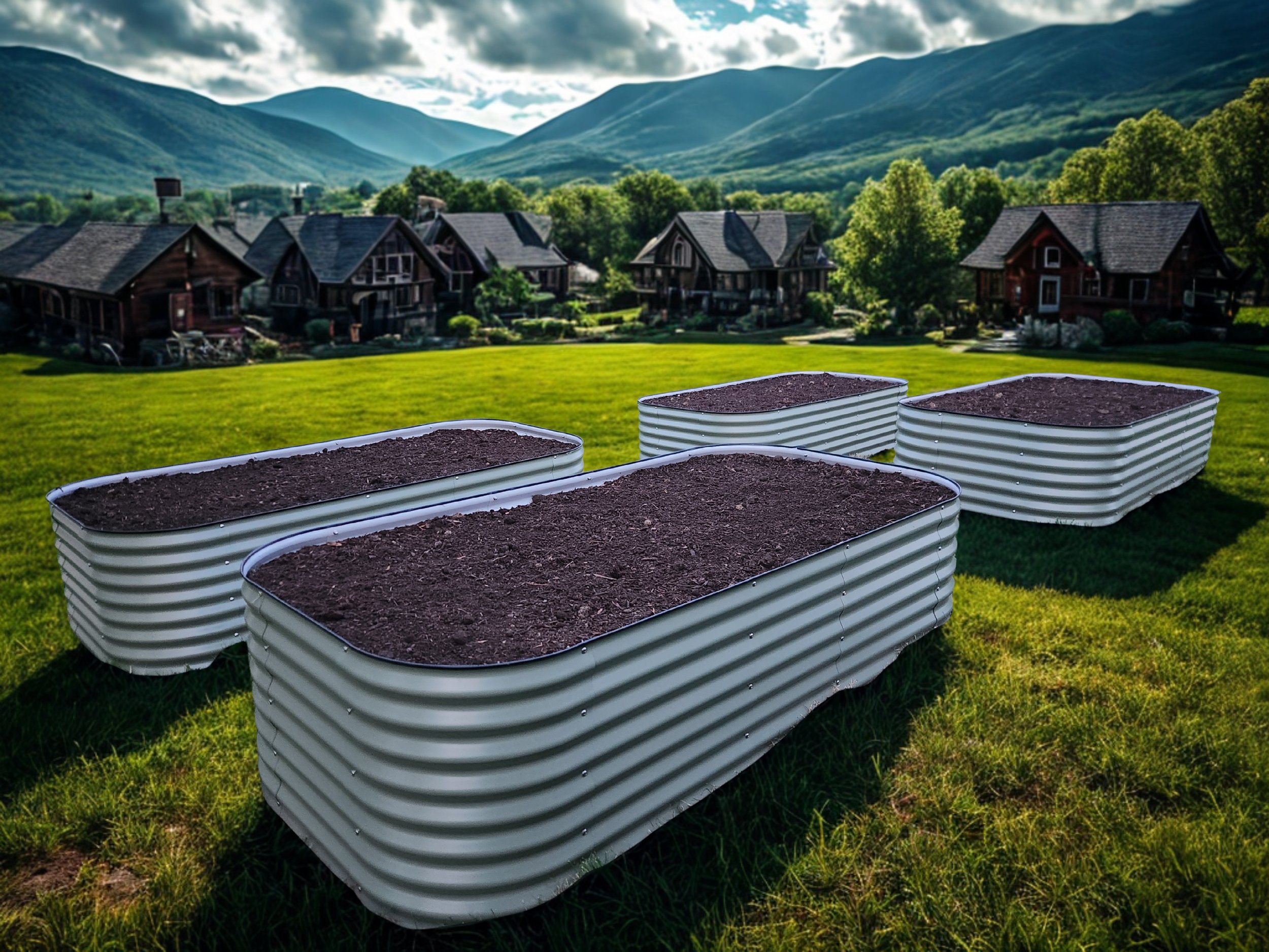 Green grassy yard with multiple metal tubs filled with dark soil, surrounded by trees and place houses with mountains in the background under a partly cloudy sky.
