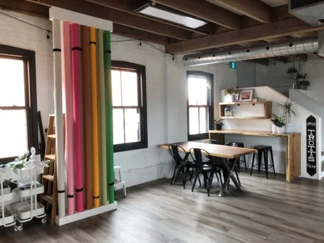 A wide angle view of the Lakeland Live Edge Tables, Bar, Bar shelf, and White Photo Stand.