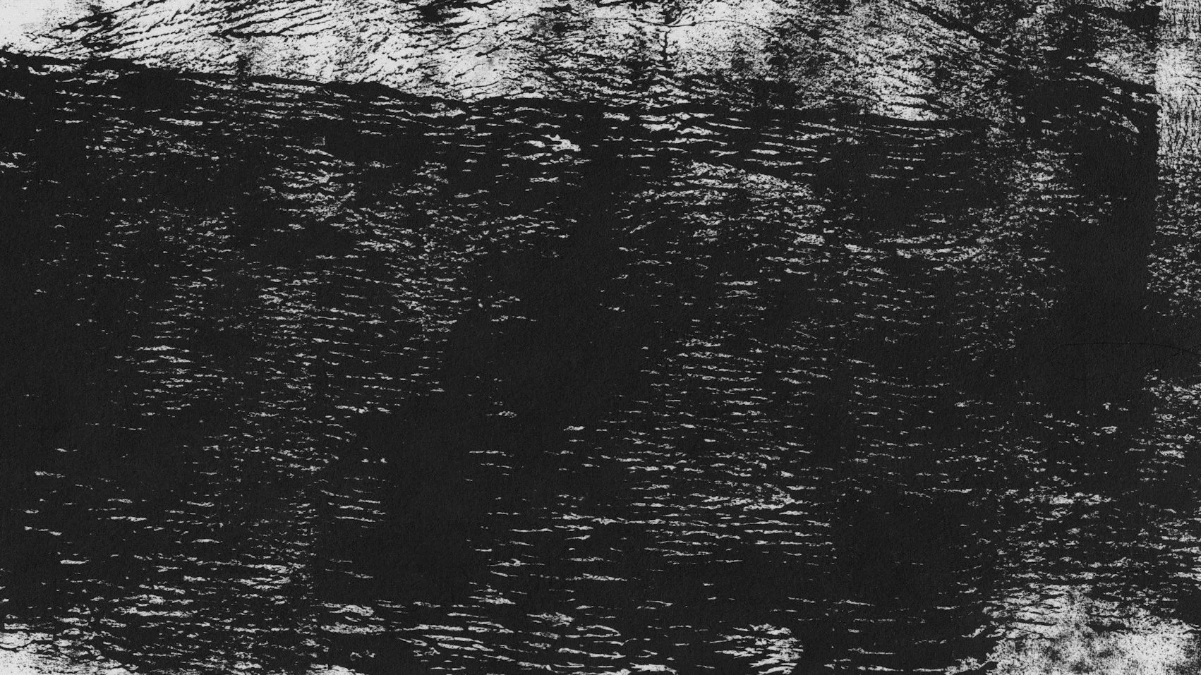 Close-up of a textured black surface with irregular white streaks and patterns.