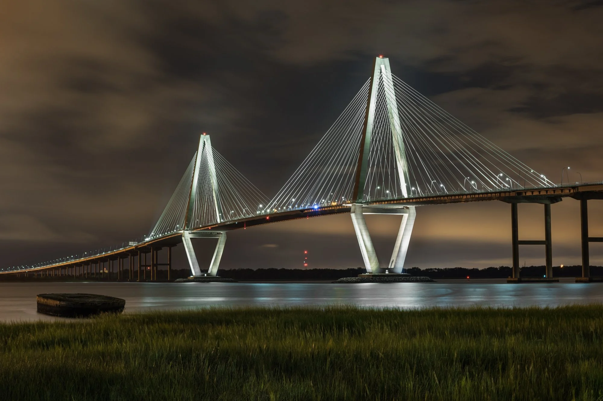 Arthur Ravenel Jr. Bridge lit up at night over the Cooper River, seen from Mount Pleasant SC