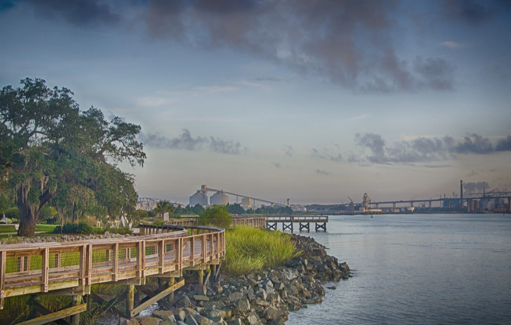 Boardwalk along the Cooper River at the former Navy Base in North Charleston SC, with port cranes in the distance