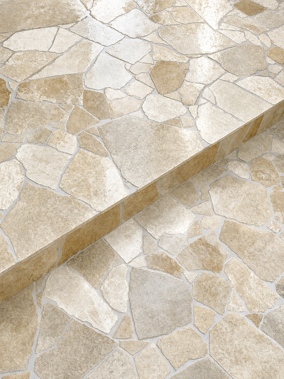 Close-up view of a beige and cream-colored mosaic tile surface with irregularly shaped stones.