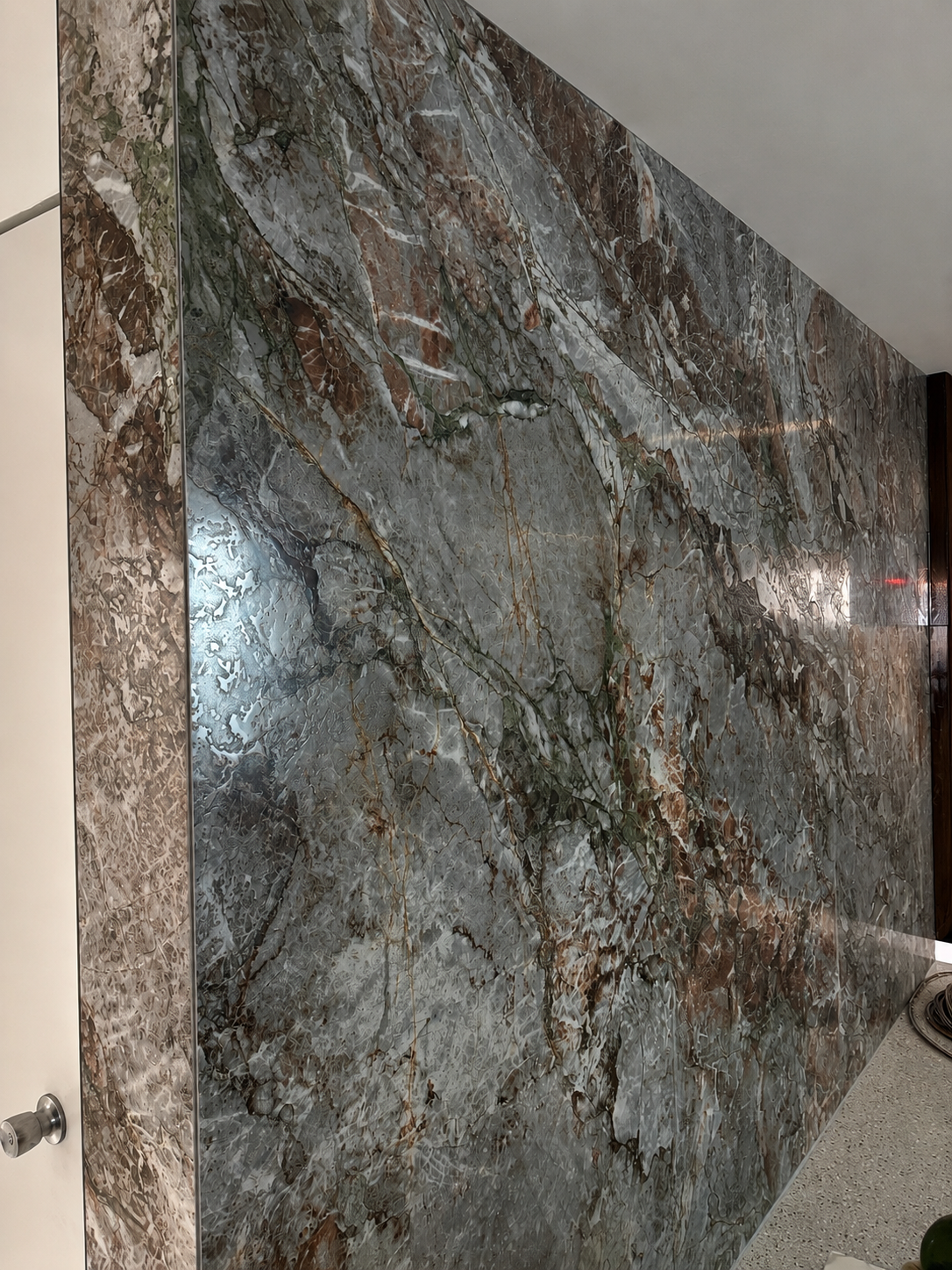 Close-up of a marble wall with intricate patterns of gray, brown, and white veining.