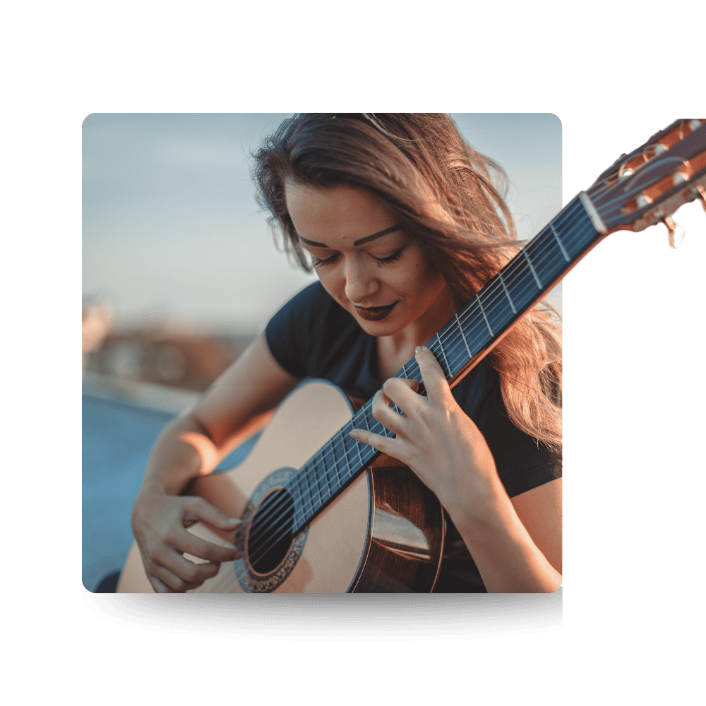 Young woman playing an acoustic guitar outdoors