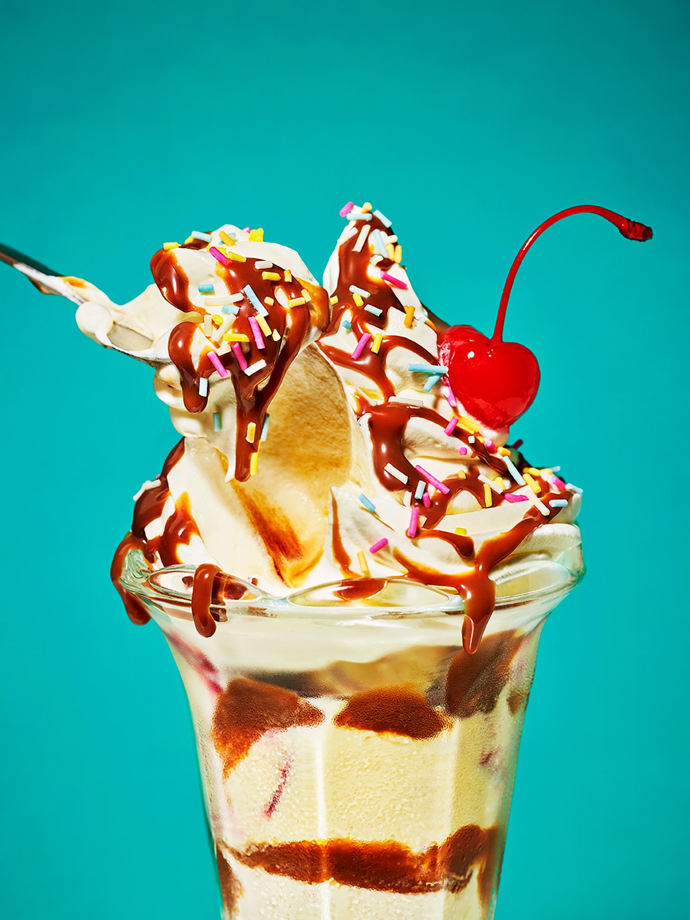 Ice cream sundae with whipped cream, sprinkles and a cherry on top.  Photography by London based food photographer Danielle Wood.