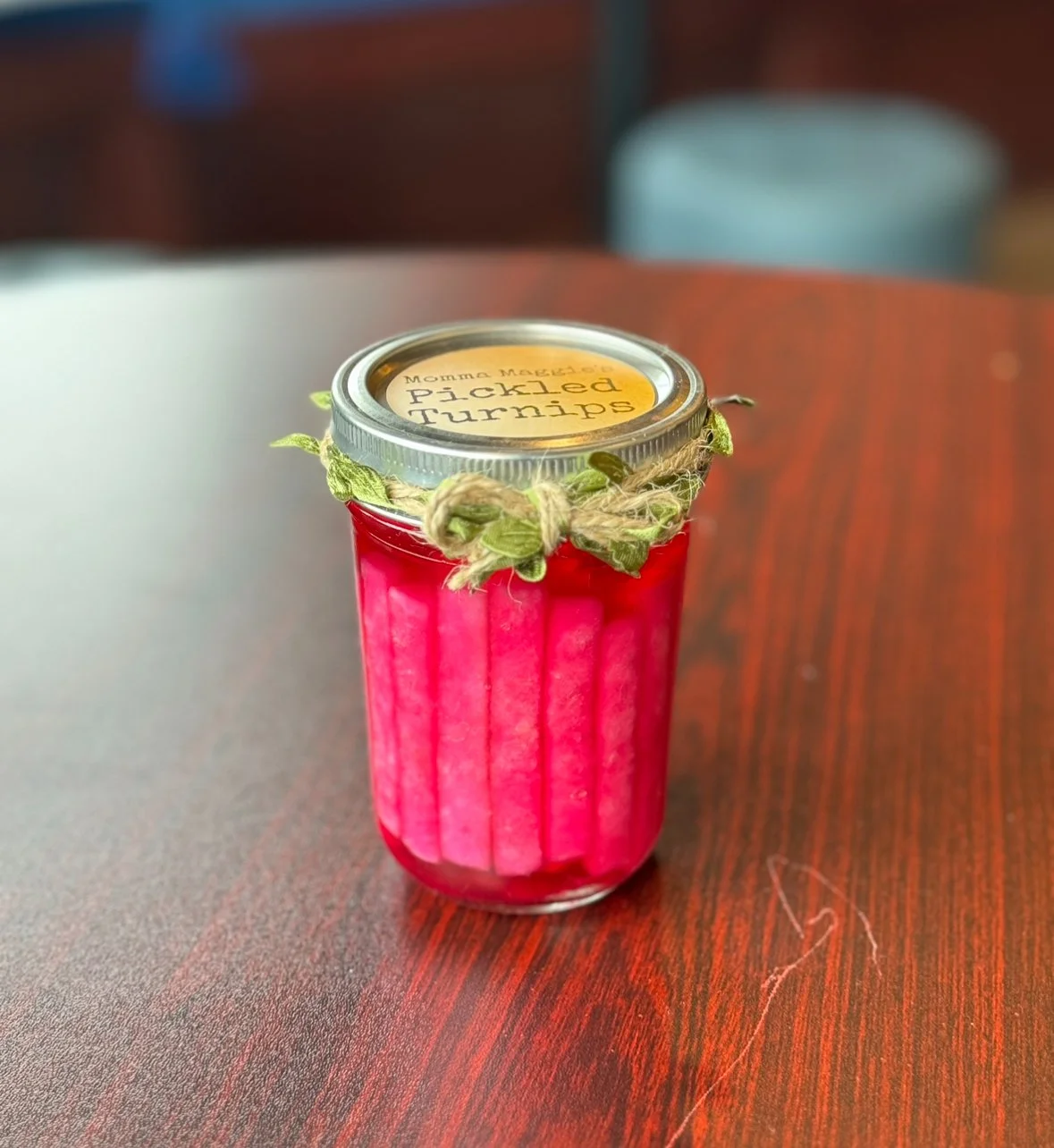 A jar of pickled turnips with a yellow label on the lid, sitting on a wooden surface.