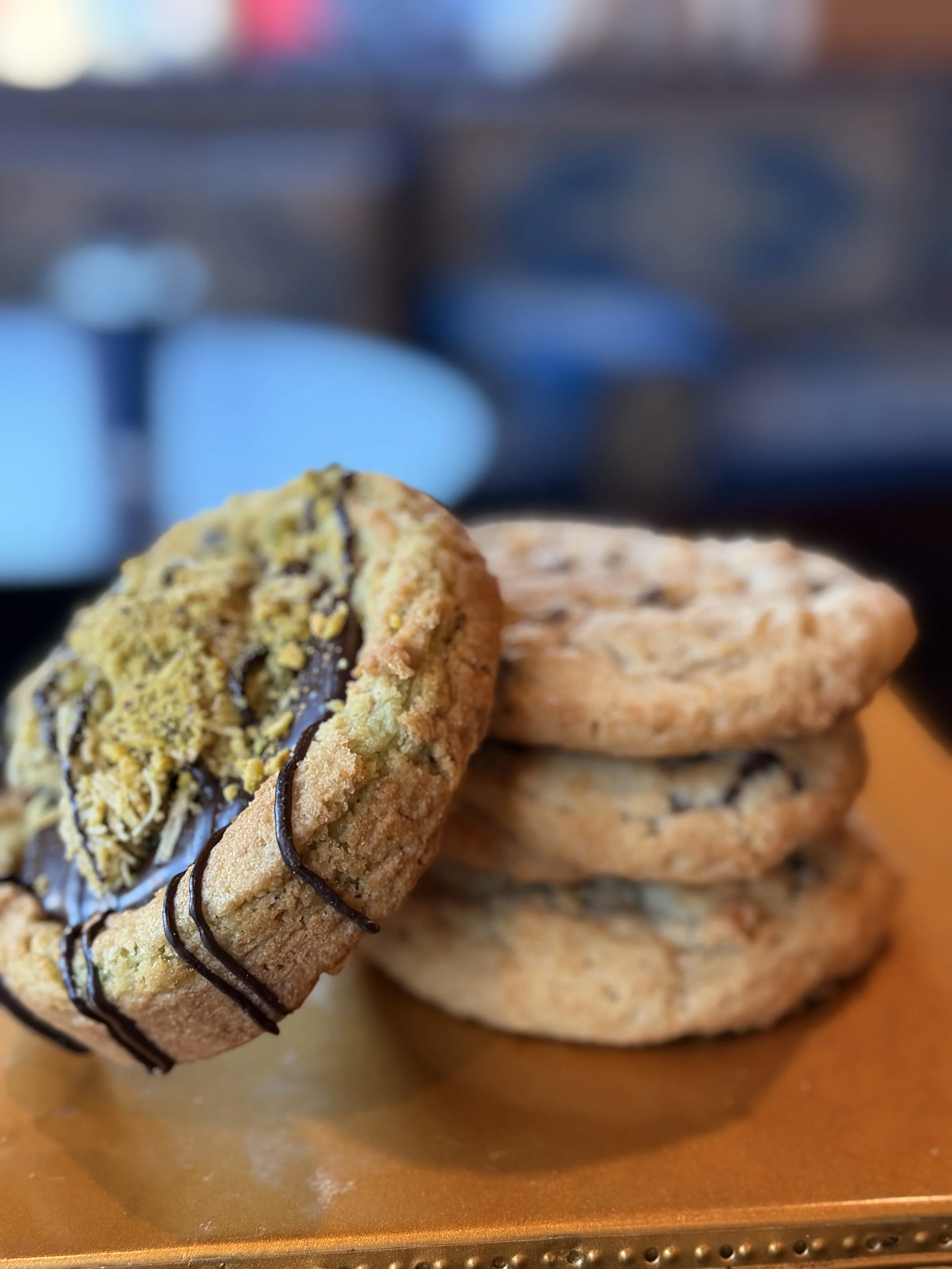 Stack of four assorted cookies on a wooden surface