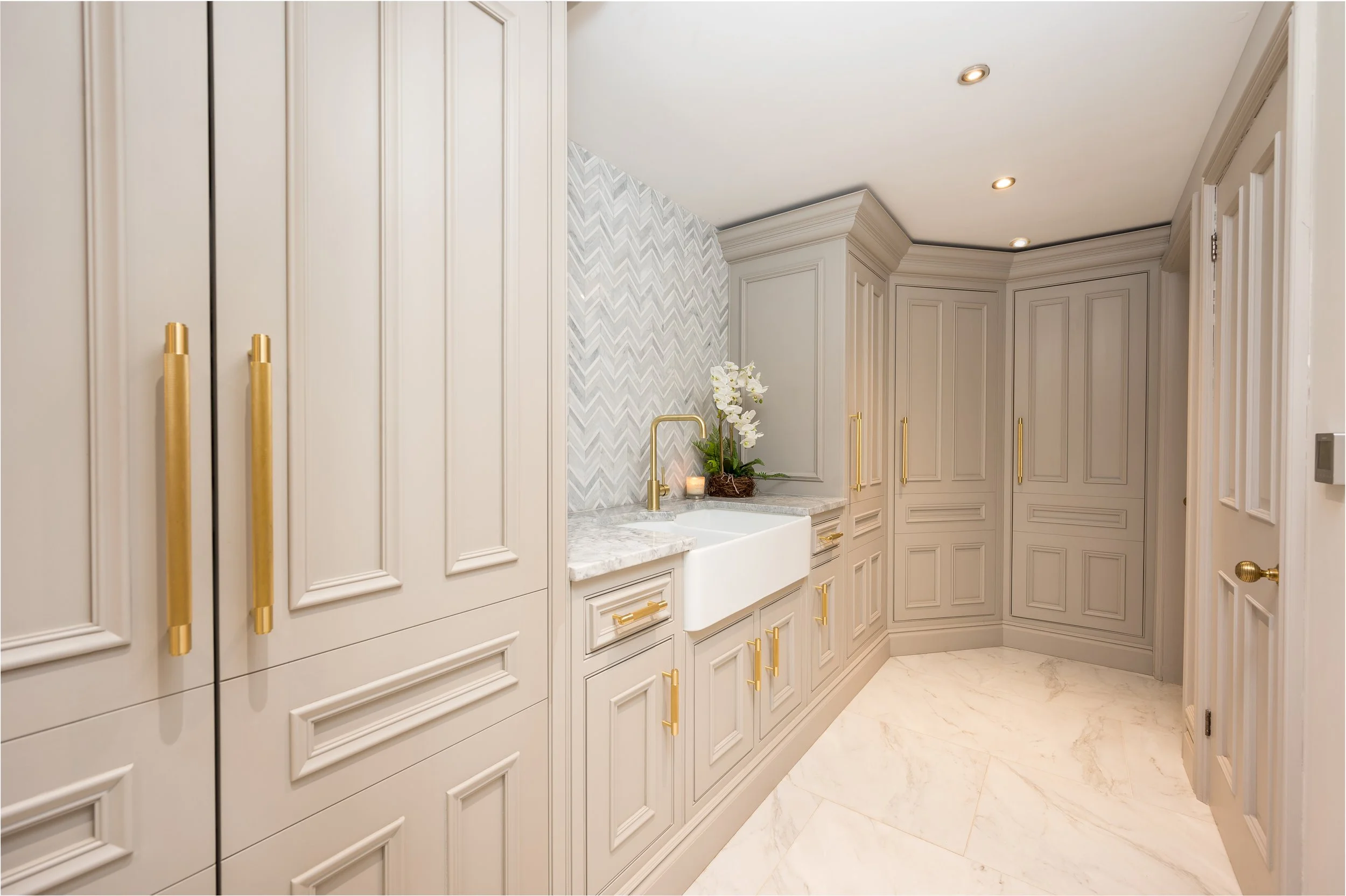 A bespoke utility room with a sink and lots of storage cupboards