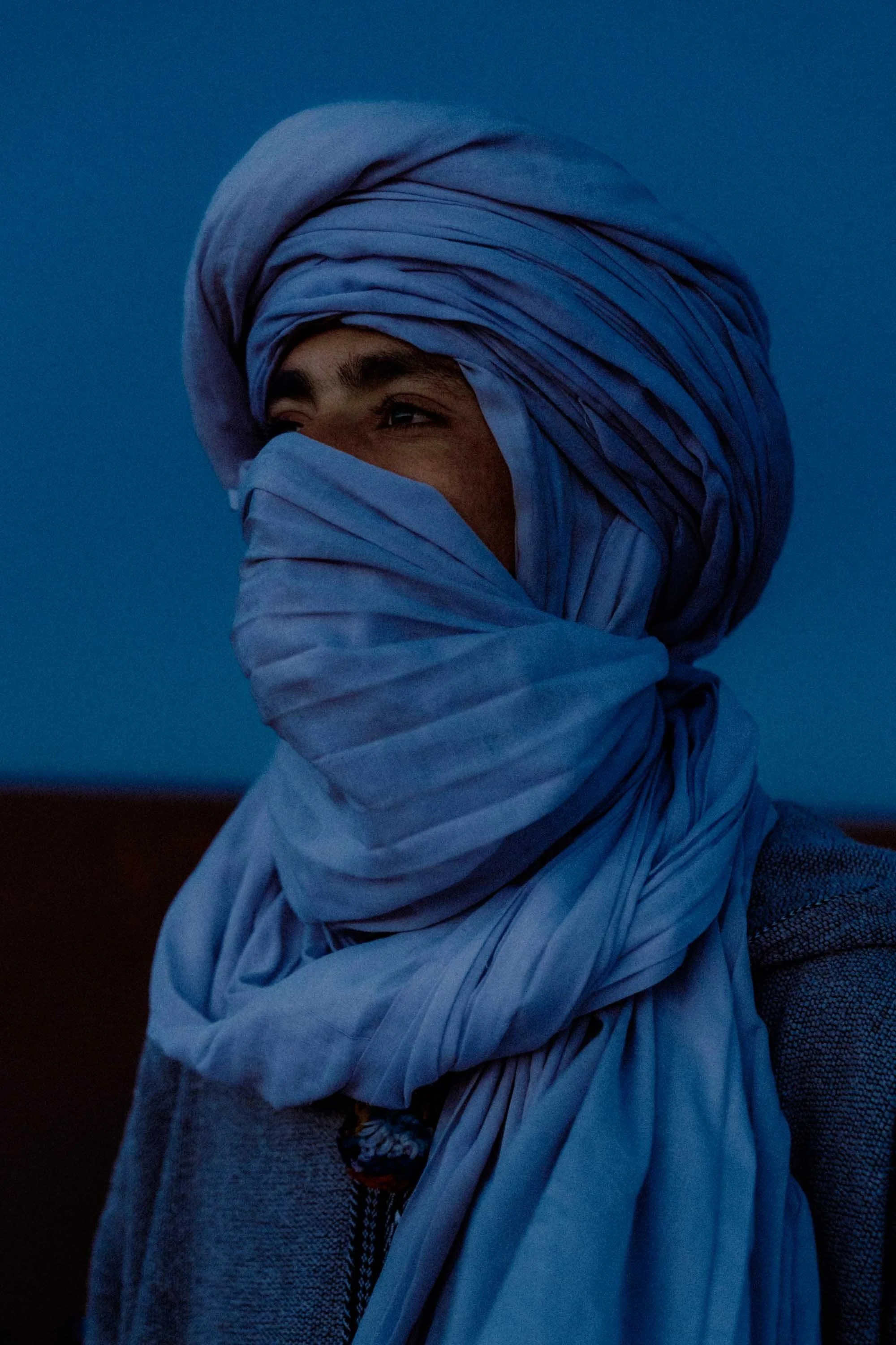 Portrait of a Touareg man wearing a traditional blue turban in the Merzouga desert, Sahara, Morocco.