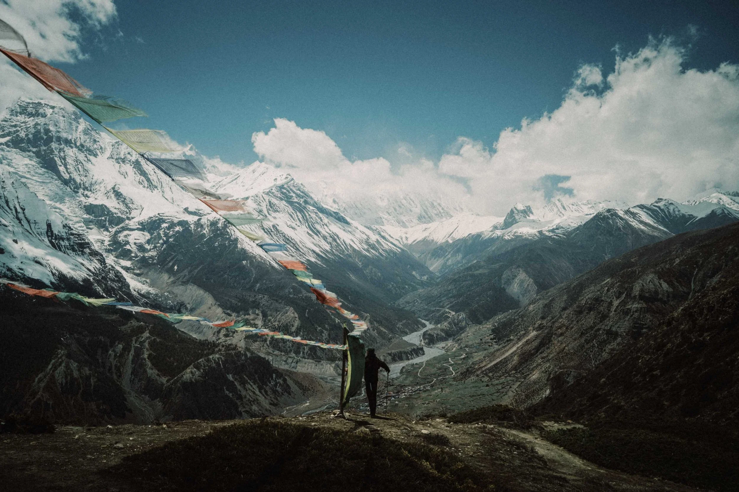 A lone hiker overlooking the majestic landscape of the Annapurna mountain range during a trek in Nepal.