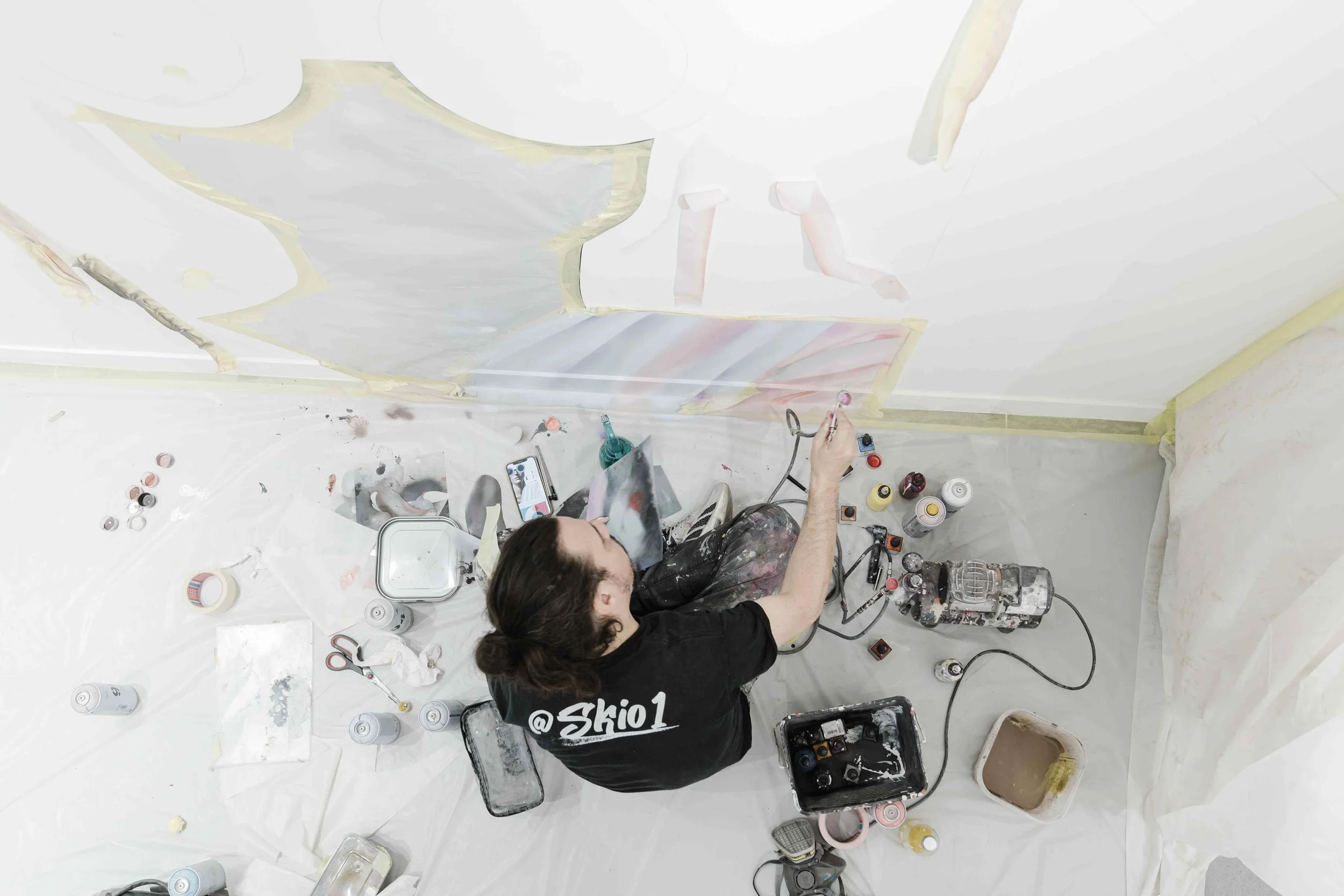 Close-up on the artist's brush applying Kiko Milano's signature colors to the Parisian store mural.