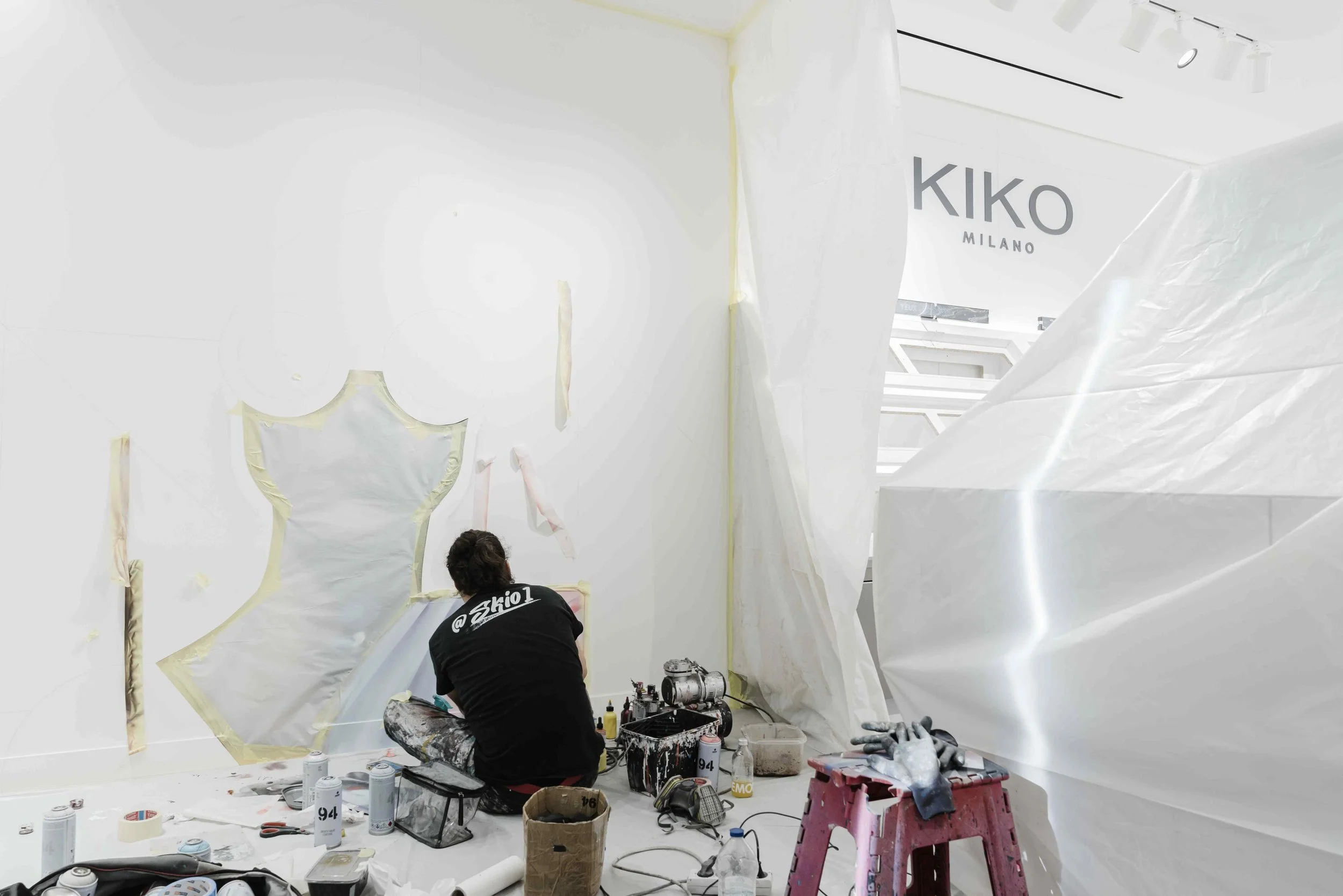 Close-up on the artist's brush applying Kiko Milano's signature colors to the Parisian store mural.