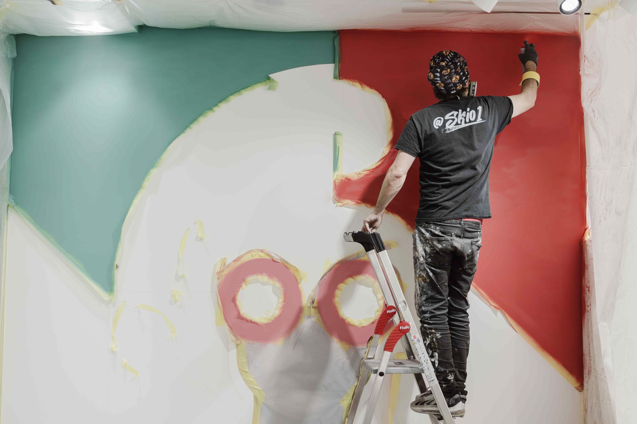 Close-up on the artist's brush applying Kiko Milano's signature colors to the Parisian store mural.