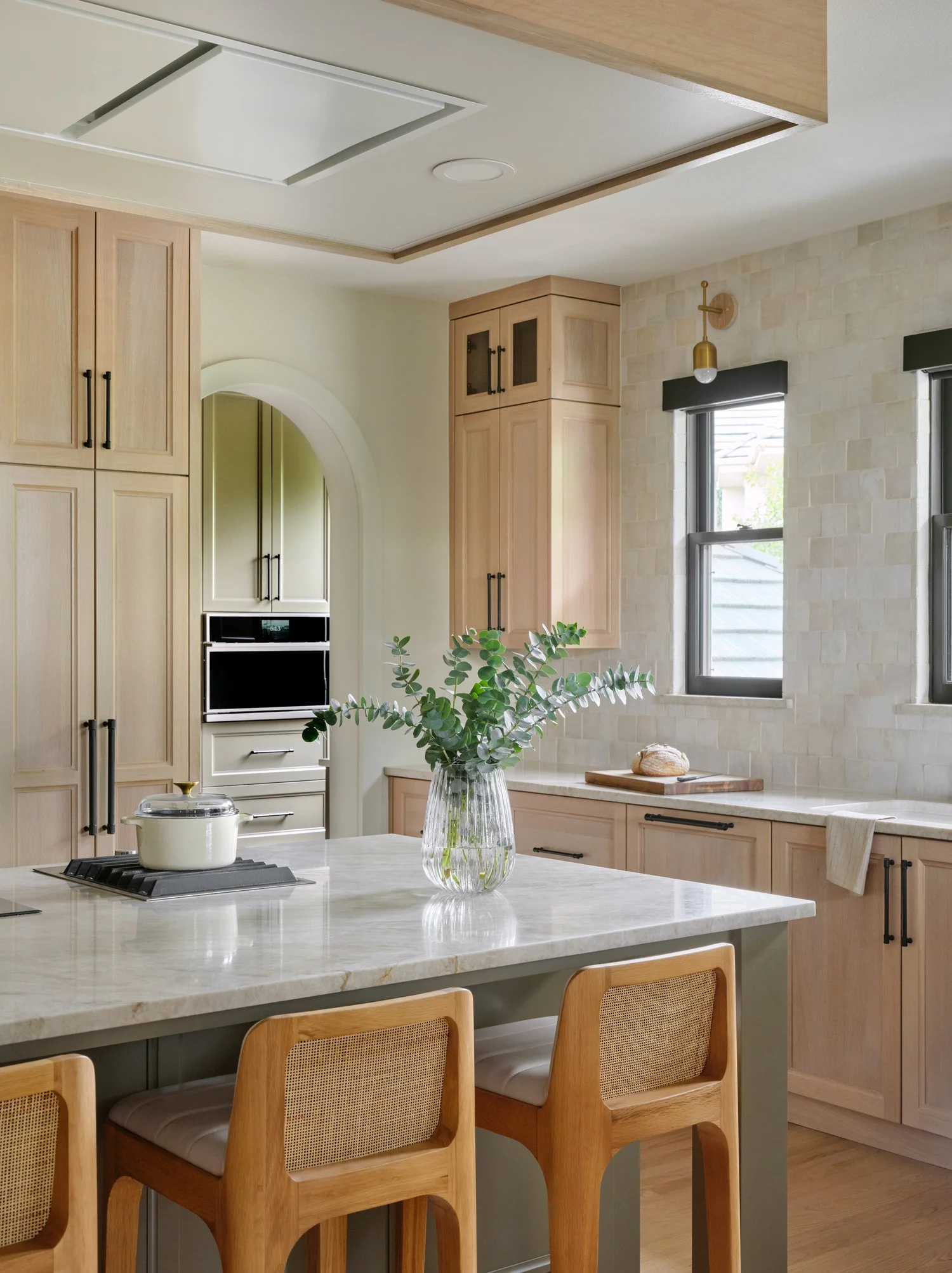 Island with the induction cooktop and wok burner, the oven wall and the pantry arch beyond