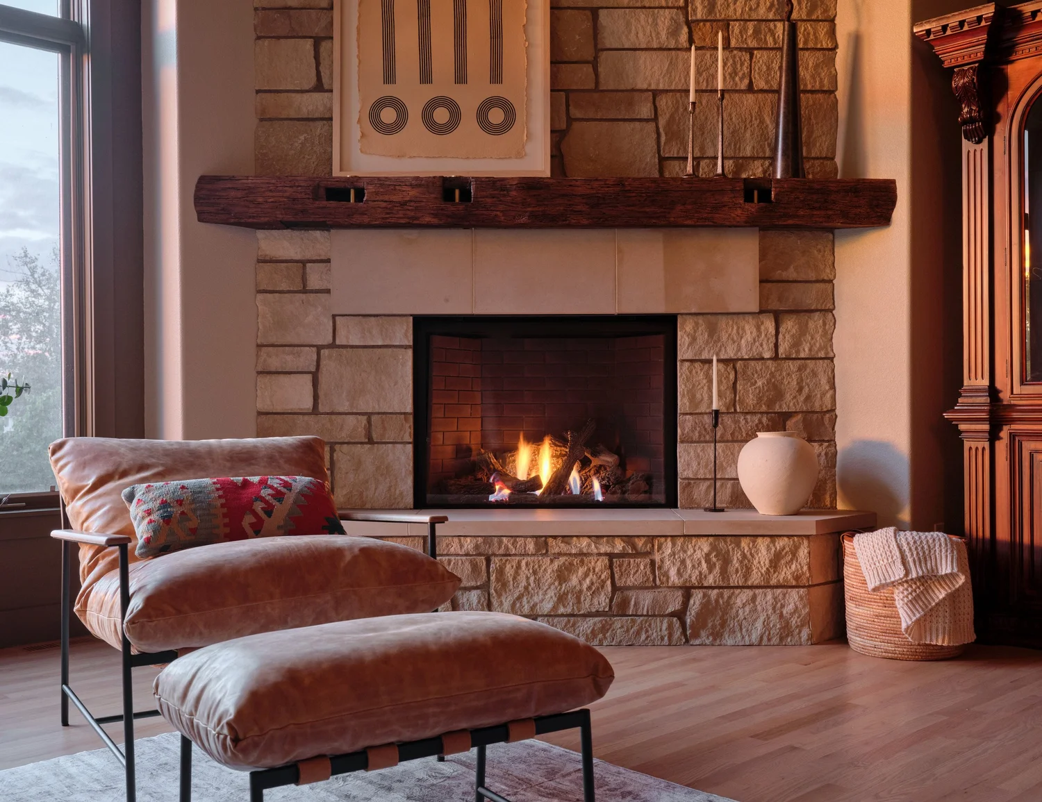Stacked stone fireplace with a reclaimed mantel and solid brass pegs