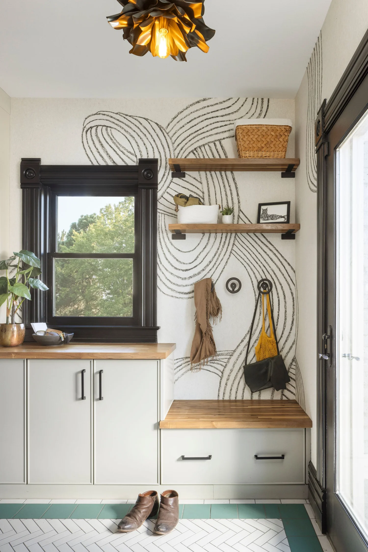 Mudroom after renovation with swirl wallpaper and custom tile floor