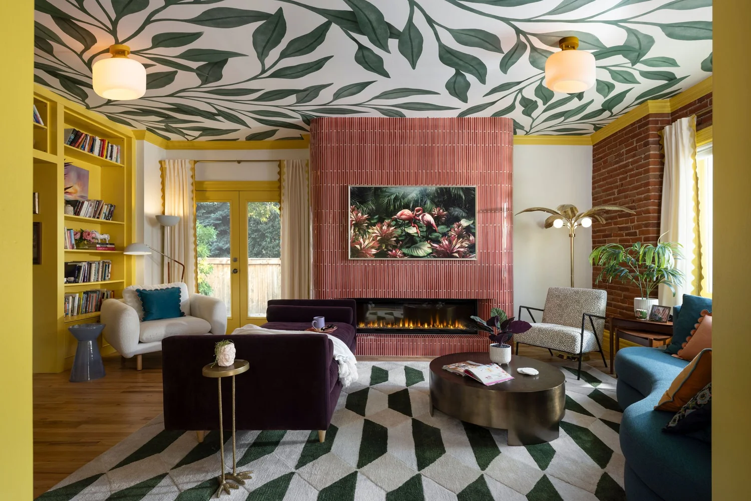 Living room after renovation with pink tile fireplace and leaf mural ceiling